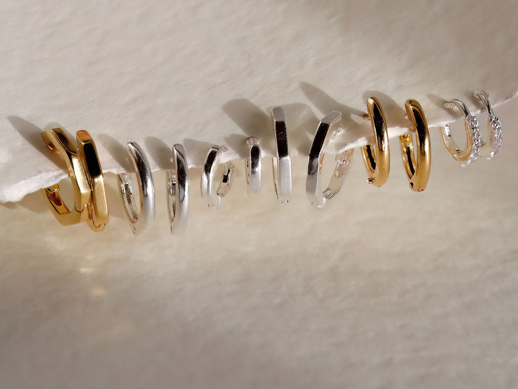 Row of huggie earrings in sterling silver and 18ct gold vermeil