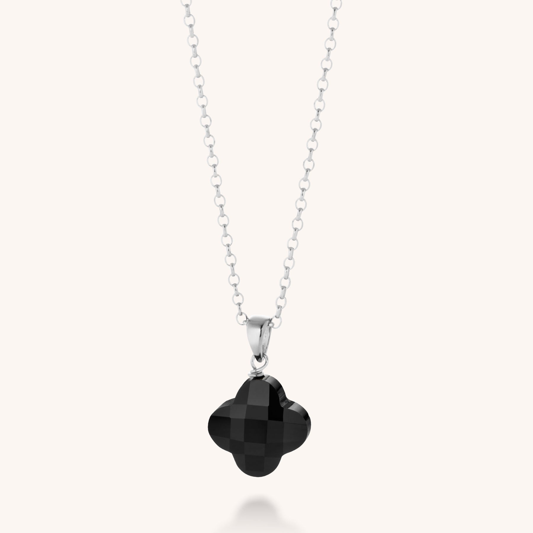 The Gem Clover Necklace features a faceted gemstone clover pendant on an elegant eco-silver chain, beautifully displayed against a plain light background.