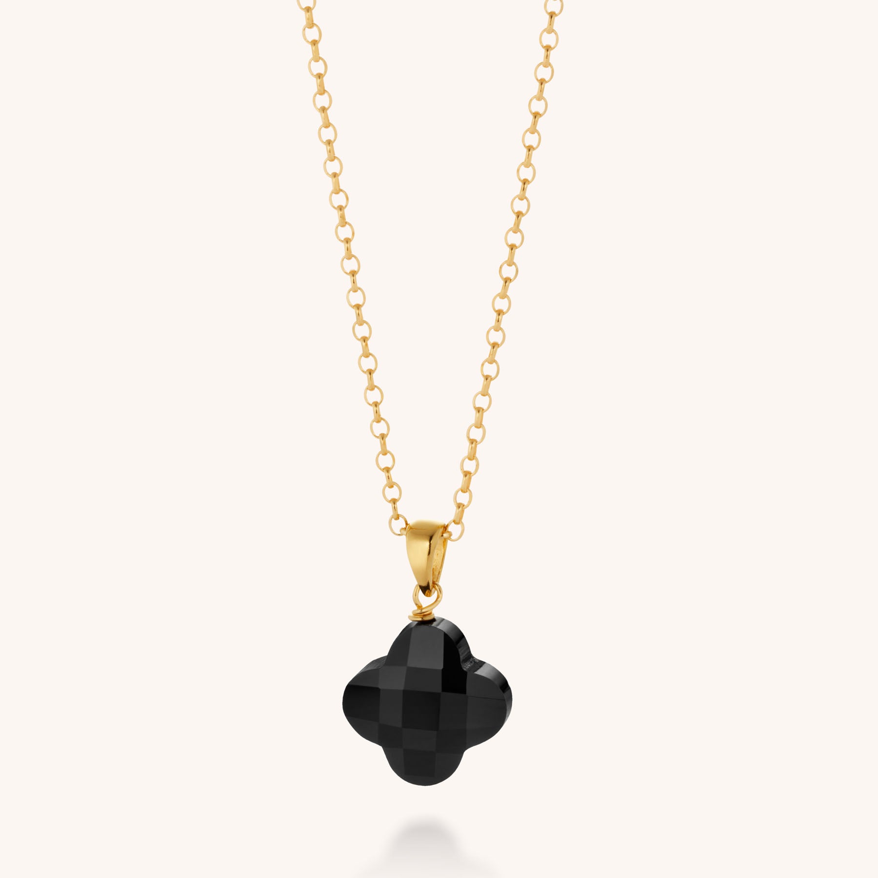 The Gem Clover Necklace features a four-leaf clover-shaped black faceted gemstone pendant, displayed on a plain light background.