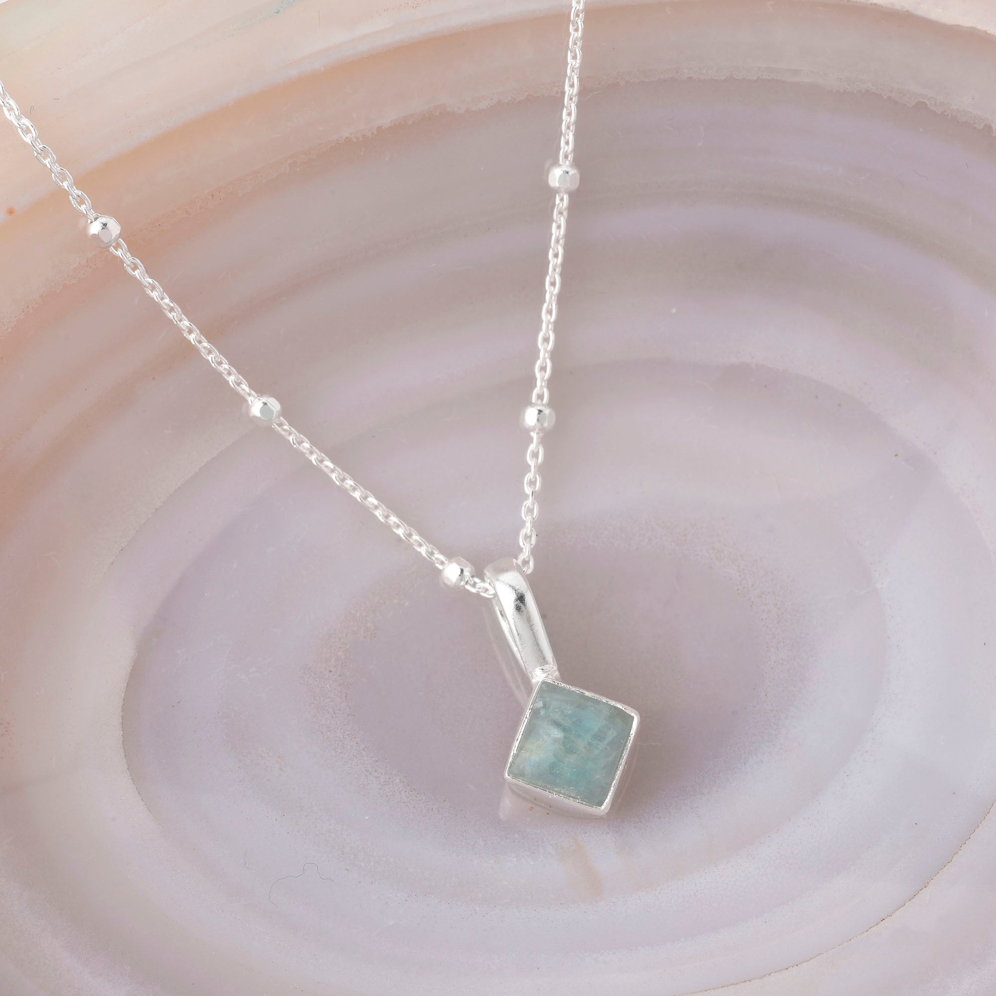 The Diamond Birthstone Necklace March features a delicate eco-silver satellite chain with small beads and a square Aquamarine gemstone pendant, making it the perfect March birthstone necklace.