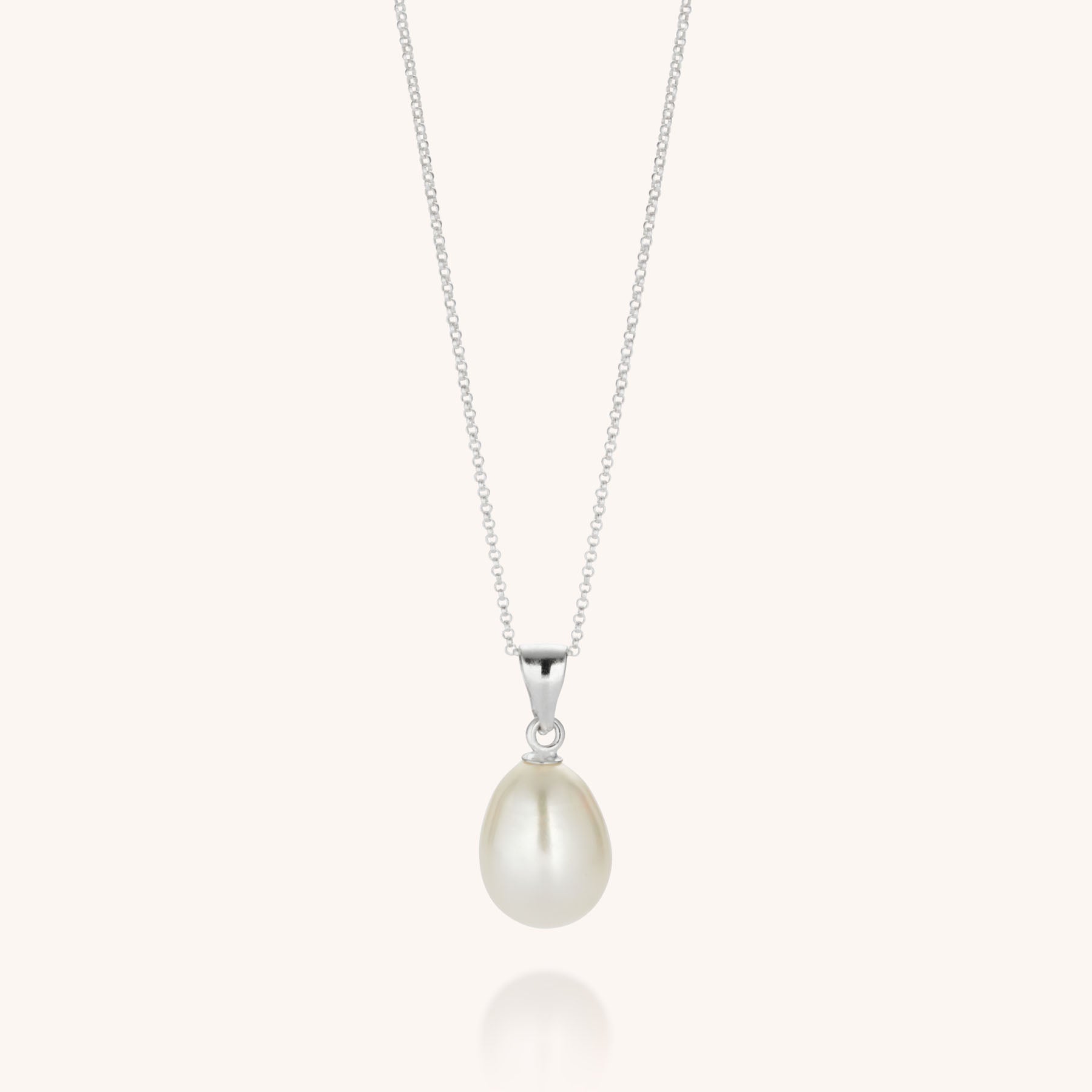 The Ellen Pearl Drop Necklace showcases a single white teardrop freshwater pearl pendant on a delicate sterling silver chain, presented against a light background—a refined, eco-friendly jewelry piece.