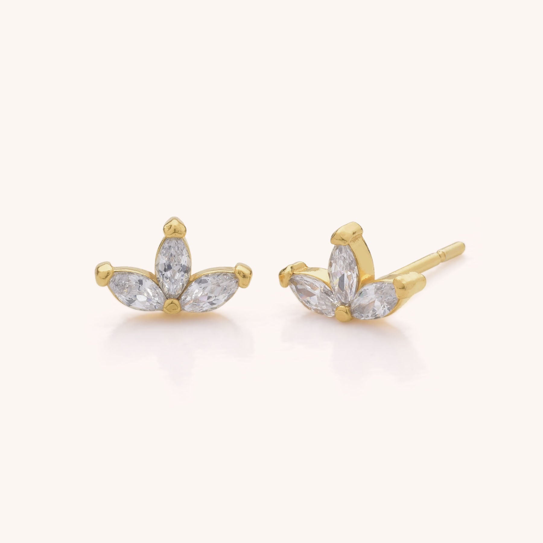 The Trio Leaf Stud Earrings feature three marquise-cut clear cubic zirconia stones in a fan shape, beautifully displayed on a light background.