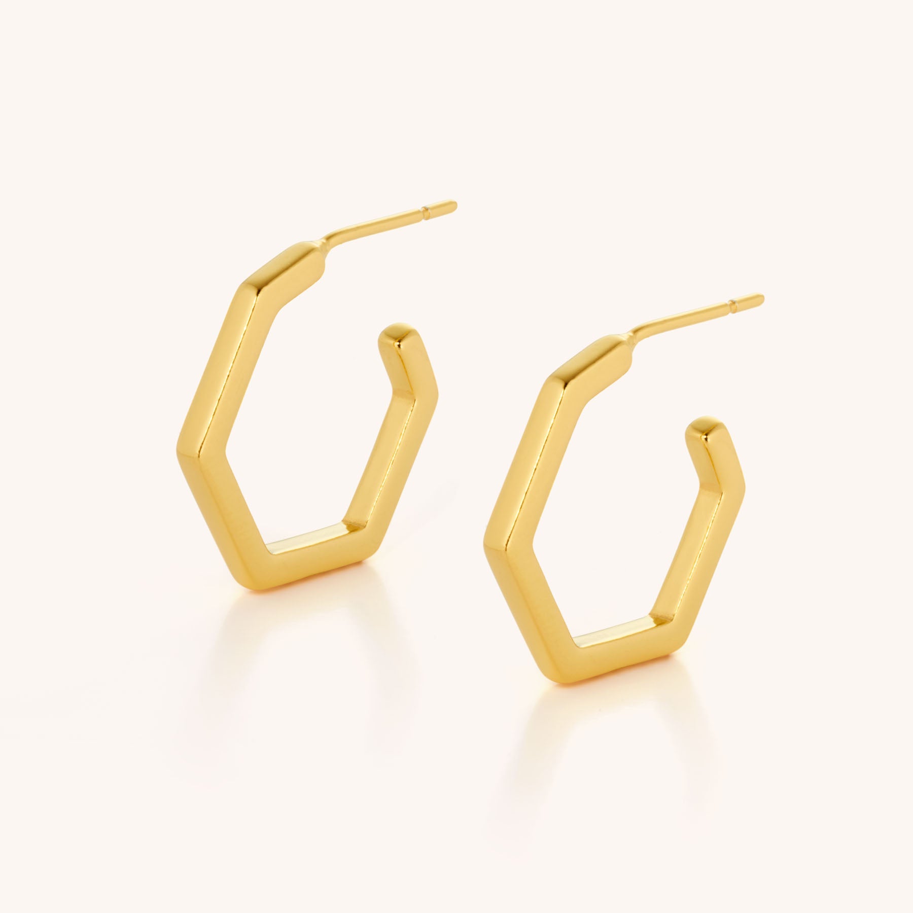 The Hex Hoop Earrings feature a sleek hexagonal shape and minimalist modern design, shown on a plain light background.