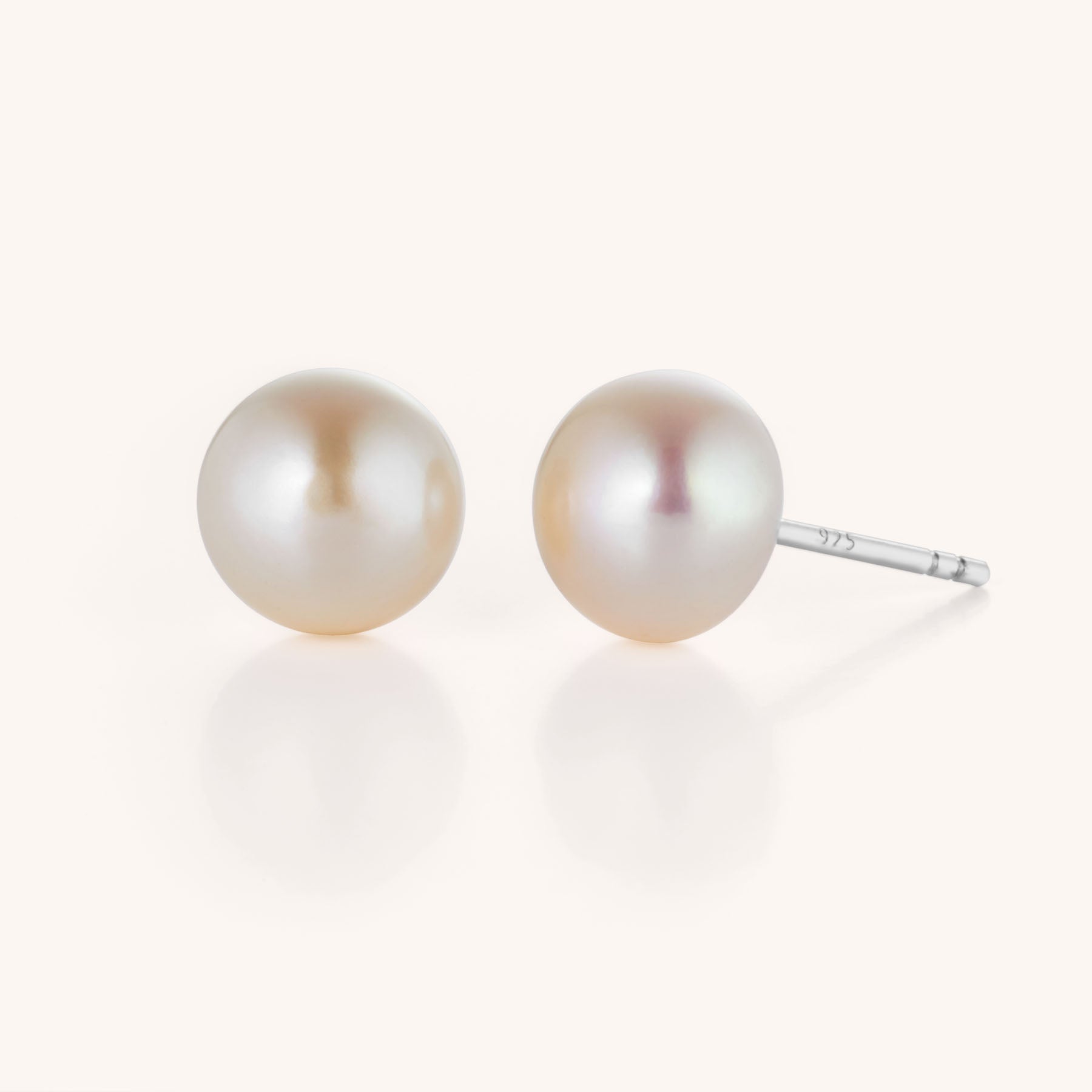 The Large Pearl Button Stud Earrings feature elegant pearl studs with silver posts, displayed on a simple, light background—perfect as a sophisticated statement piece for any jewelry collection.