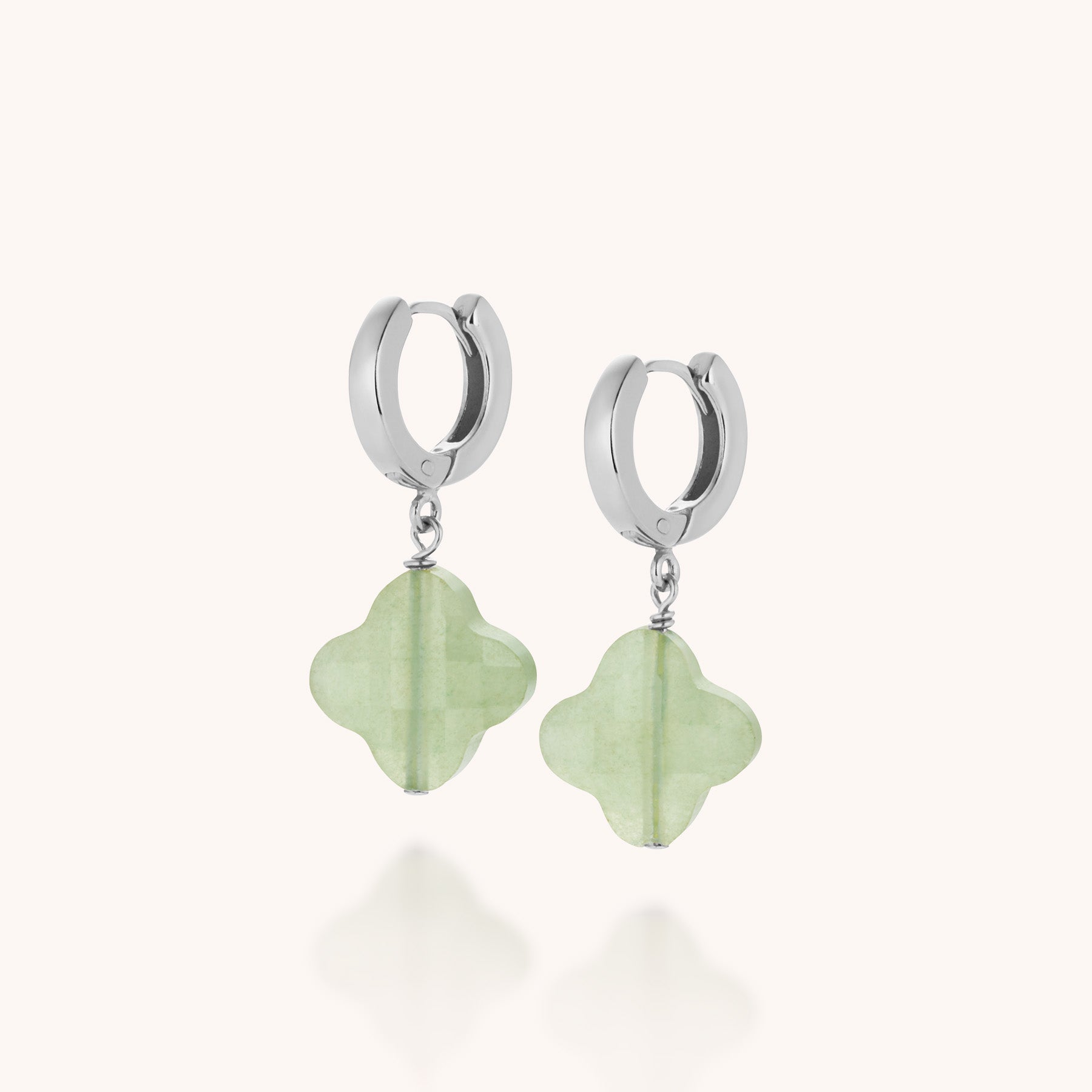 Clover Gem Hoop Earrings: Sterling silver hoops with dangling four-leaf clover-shaped light green gemstones, shown on a plain white background.
