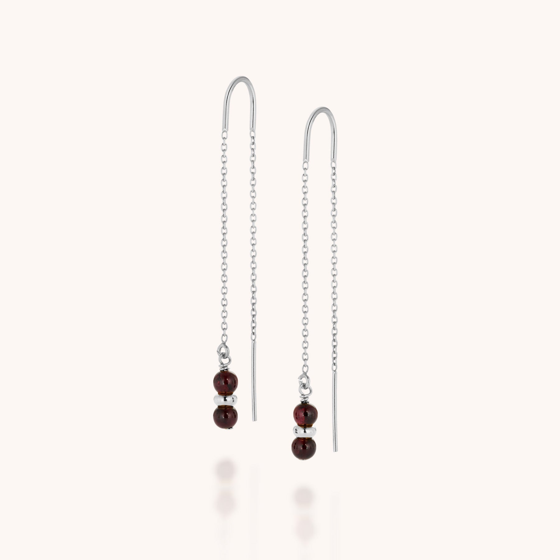 Delicate silver threader earrings with double dark red beads at each end, these Fall Earrings Birthstone January make perfect garnet jewelry, beautifully shown against a simple light background.
