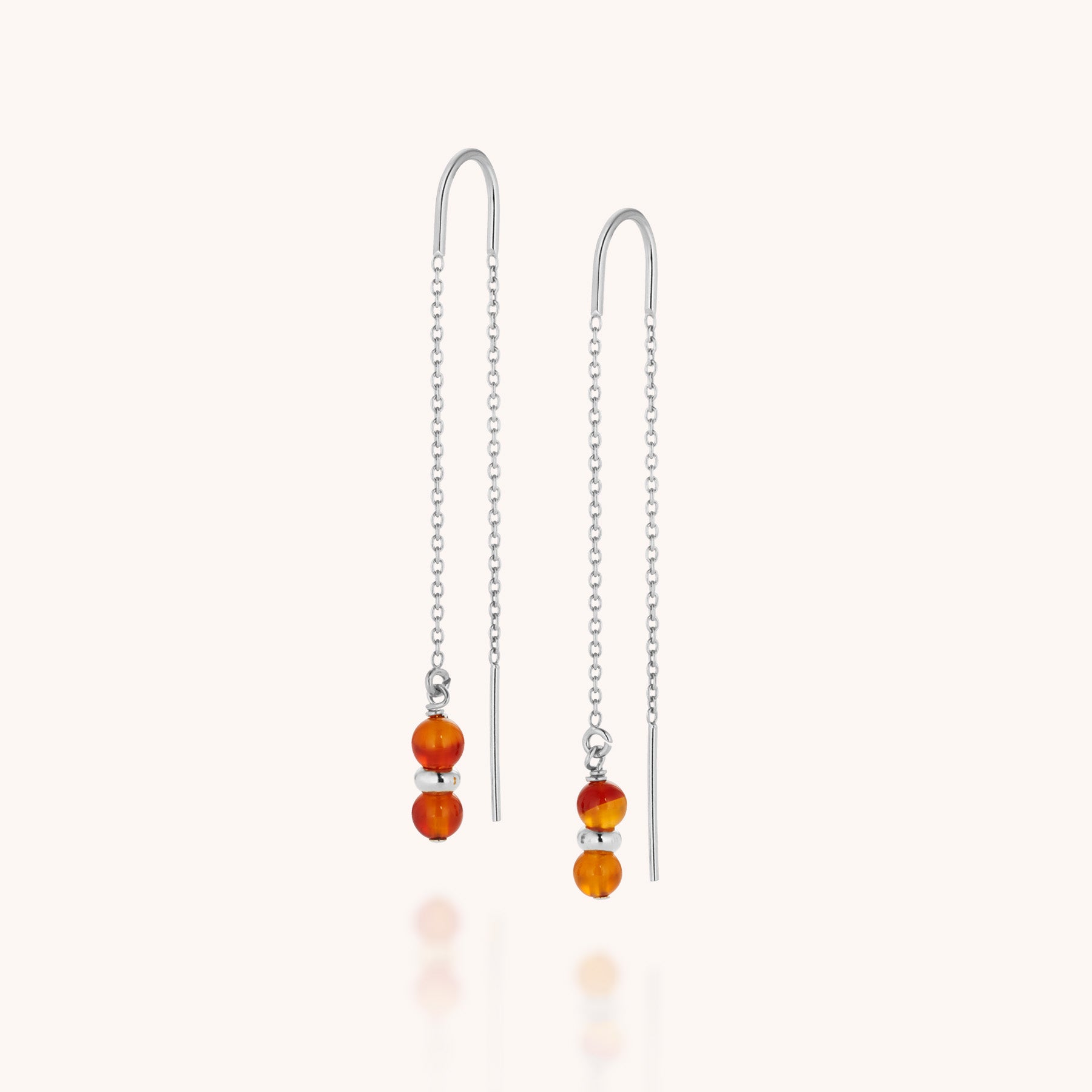 A pair of Fall Earrings Birthstone July featuring two small, round carnelian gemstone beads dangling from each silver threader earring, displayed against a plain white background.
