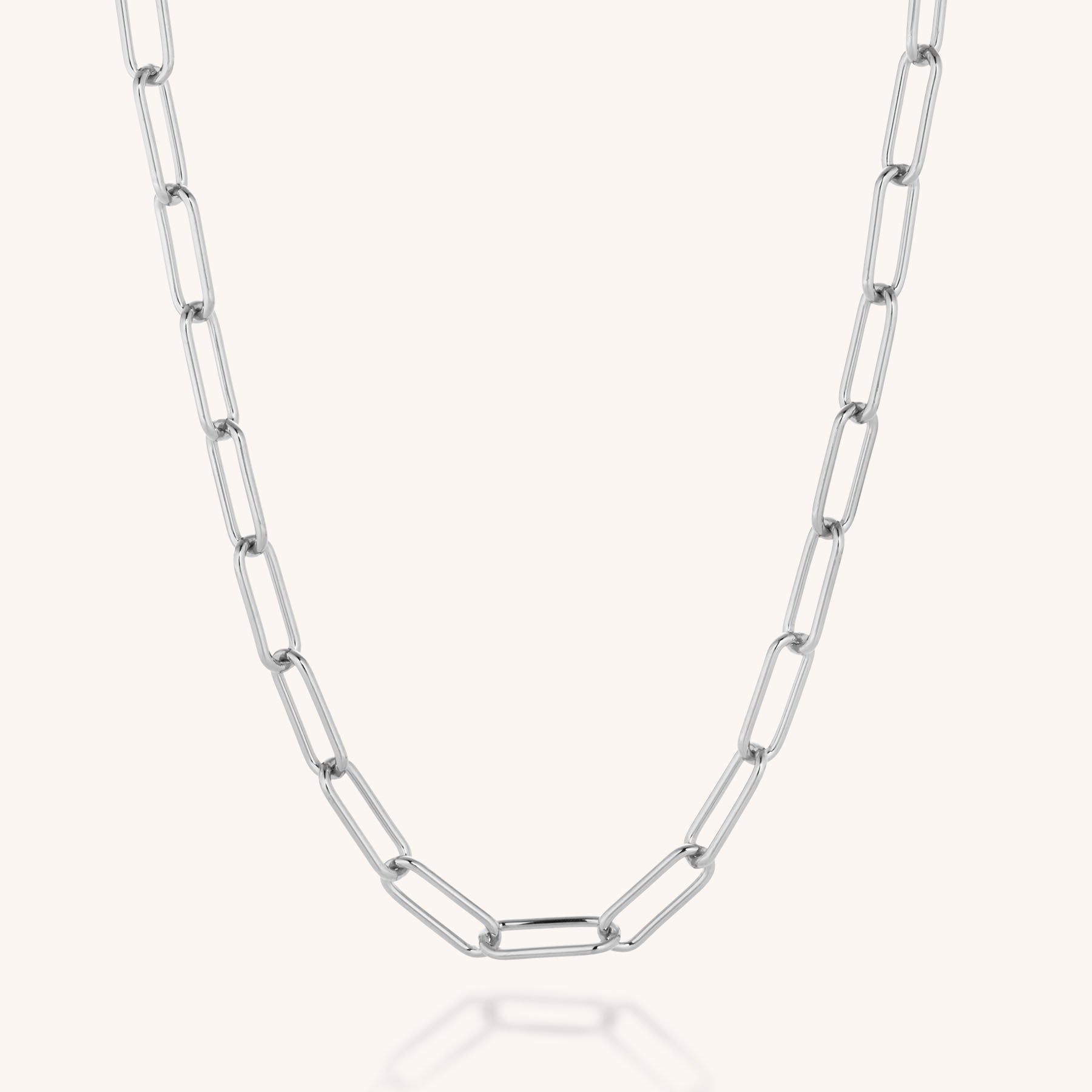 The Paperclip Necklace, crafted from eco silver with elongated rectangular links, is displayed on a plain light background. Its gentle curve accentuates the modern, minimalist design.