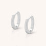 The Nell Huggie Earrings, crafted from polished sterling silver in a minimalist style, are displayed upright on a light, neutral background.