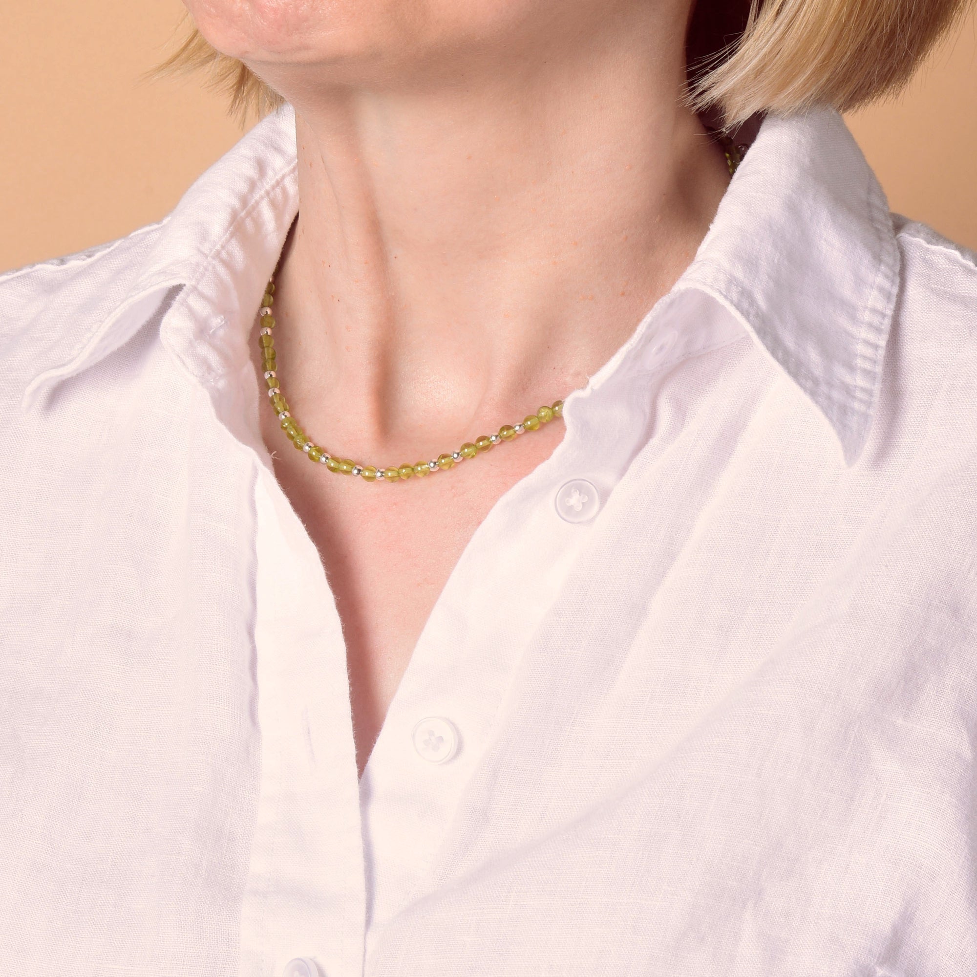 Lady in white shirt with peridot necklace
