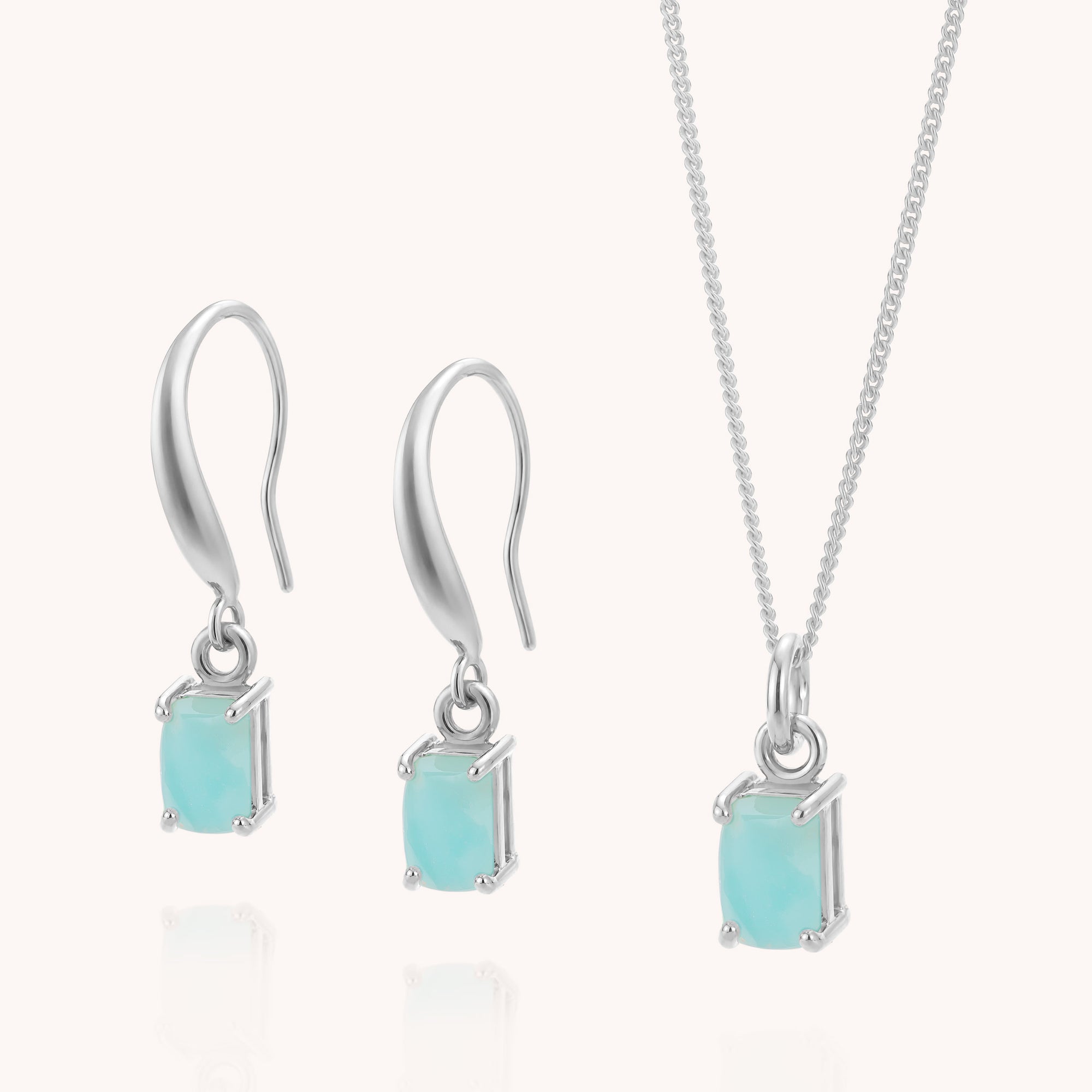 Silver jewelry set featuring drop earrings and a chain necklace, each adorned with a rectangular, light blue amazonite gemstone in a prong setting, displayed on a light background. The elegant Amazonite Octavia Necklace &amp; Earrings Set makes a timeless sterling silver gift for any occasion.