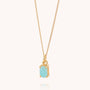 The Amazonite Octavia Necklace showcases a delicate gold chain adorned with a small, rectangular light blue Amazonite gemstone pendant, set in an elegant gold prong setting and displayed against a simple, light background.