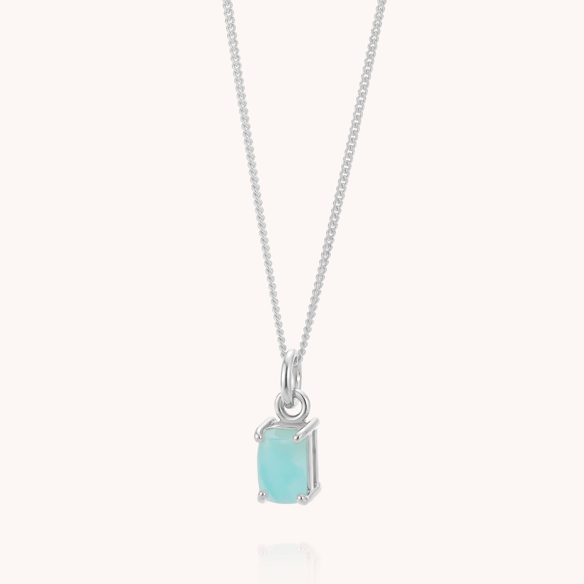 The Amazonite Octavia Necklace features a delicate sterling silver chain with a small, rectangular aqua blue amazonite gemstone pendant set in a simple four-prong setting. This elegant necklace embodies understated beauty with its refined design and subtle shimmer.
