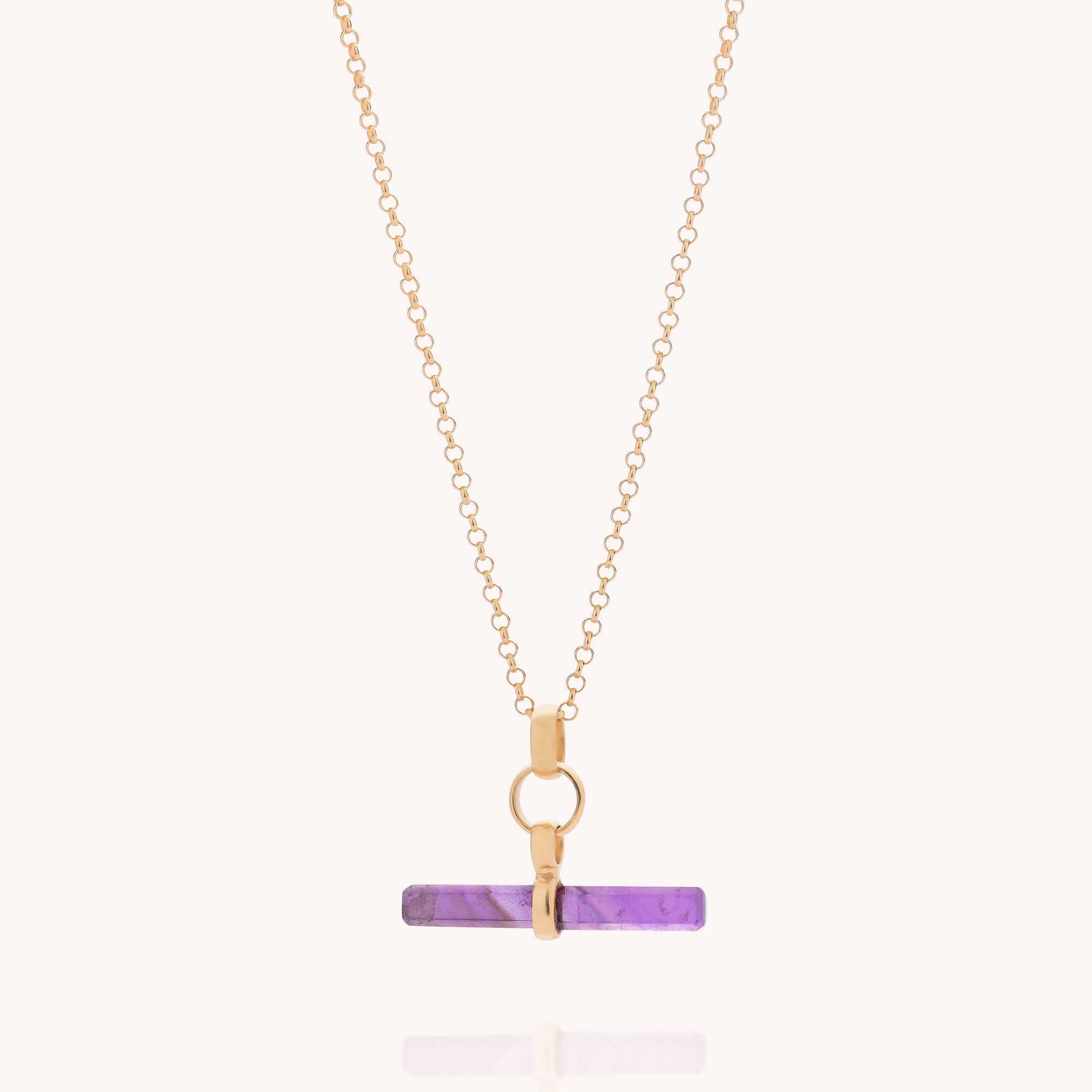 Amethyst T-Bar Necklace—an elegant gold chain necklace featuring a horizontal cylindrical purple amethyst pendant, secured with a gold ring and bail, displayed against a plain light background. This refined piece of gemstone jewellery adds a sophisticated pop of color to any collection.