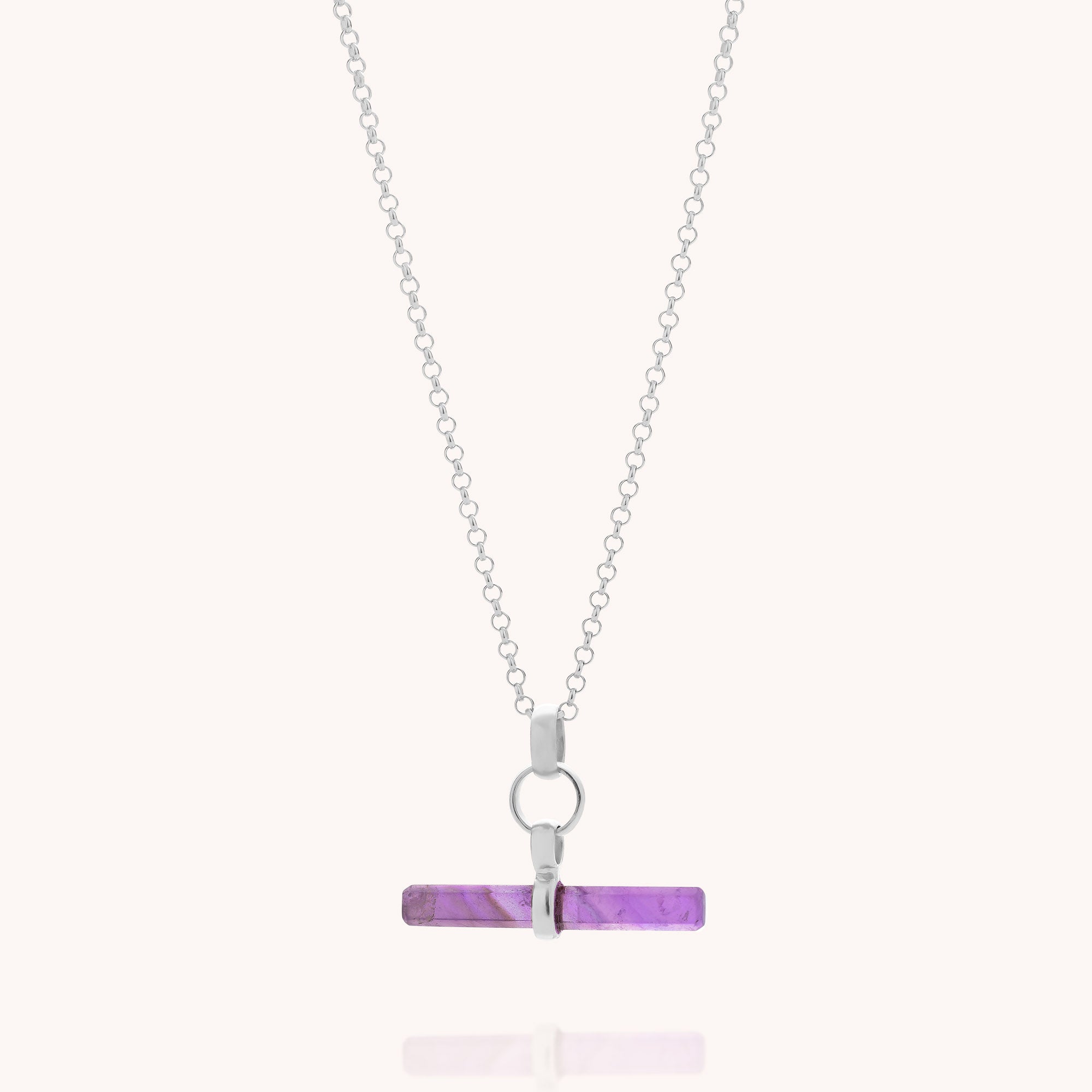 Introducing the Amethyst T-Bar Necklace: a sterling silver chain necklace showcasing a horizontal, rectangular amethyst pendant elegantly suspended from a sleek silver loop. This modern and minimalist design creates a striking silhouette against any background, making the Amethyst T-Bar Necklace an ideal addition to contemporary gemstone jewellery collections.
