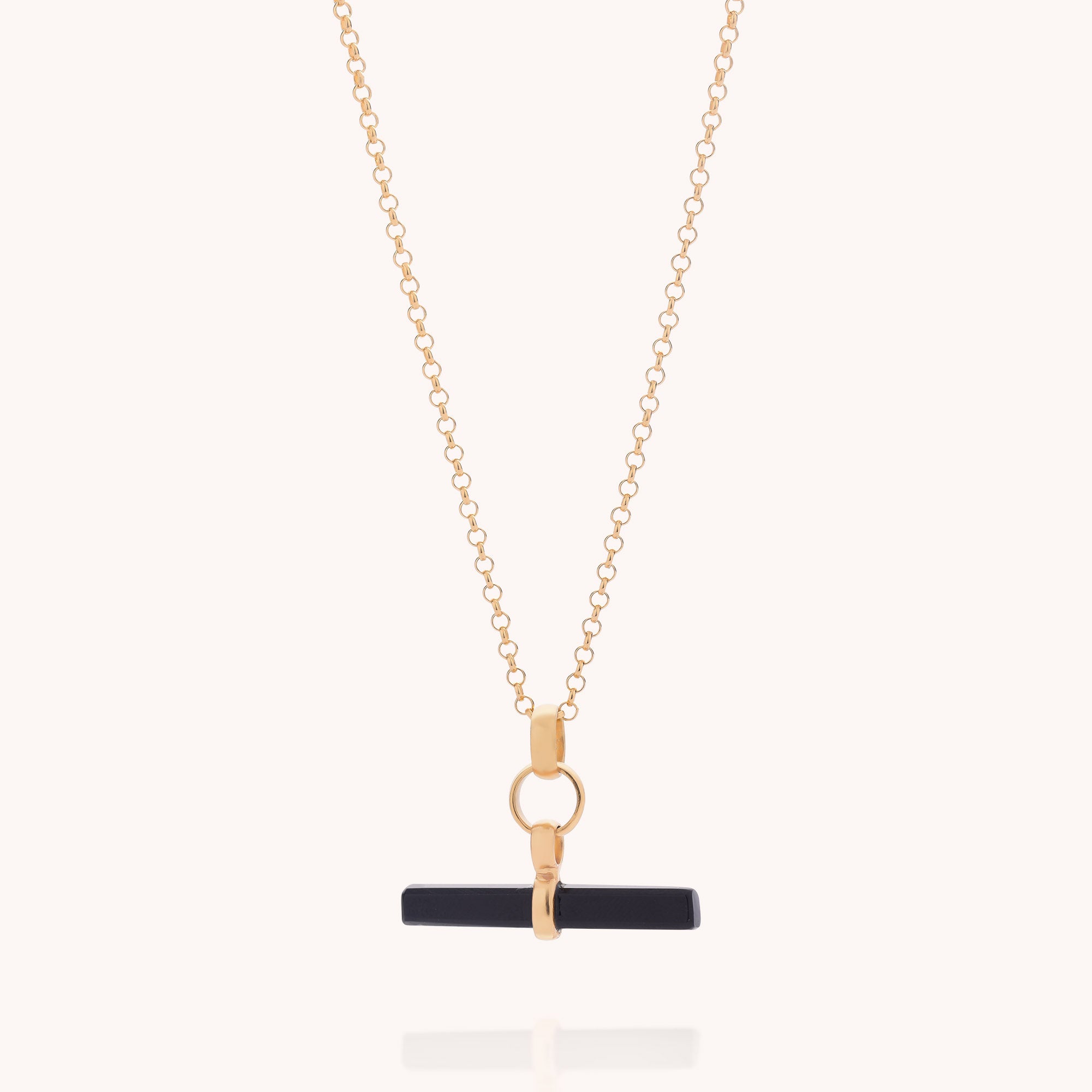 The Black Onyx T-Bar Necklace features a horizontal black onyx bar pendant secured by a gold clasp, elegantly showcasing gemstone jewellery and displayed against a plain, light background.