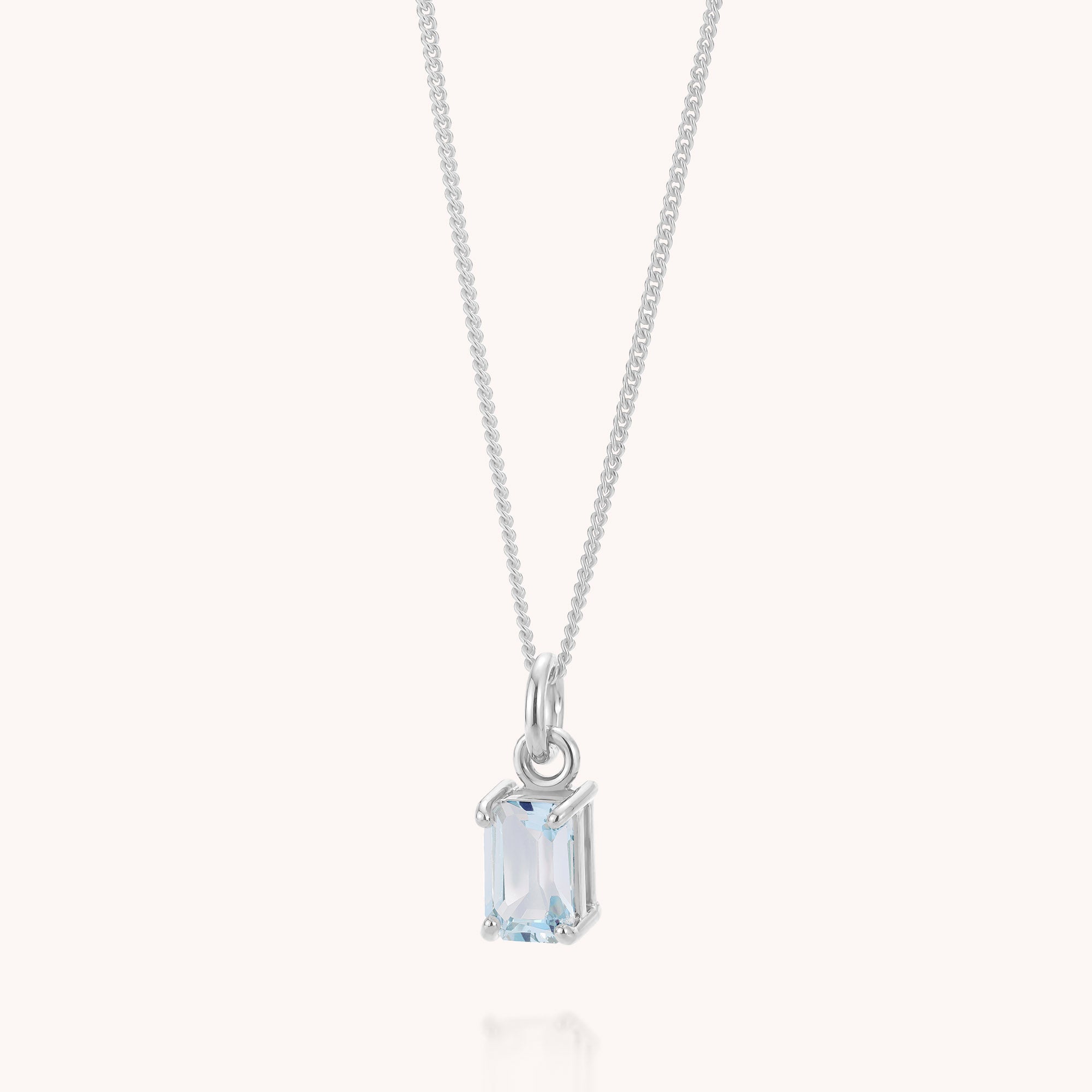 The Blue Topaz Octavia Necklace is a delicate sterling silver piece featuring a rectangular light blue topaz gemstone pendant—reminiscent of the December birthstone—set in a minimalist prong setting and showcased against a plain white background.