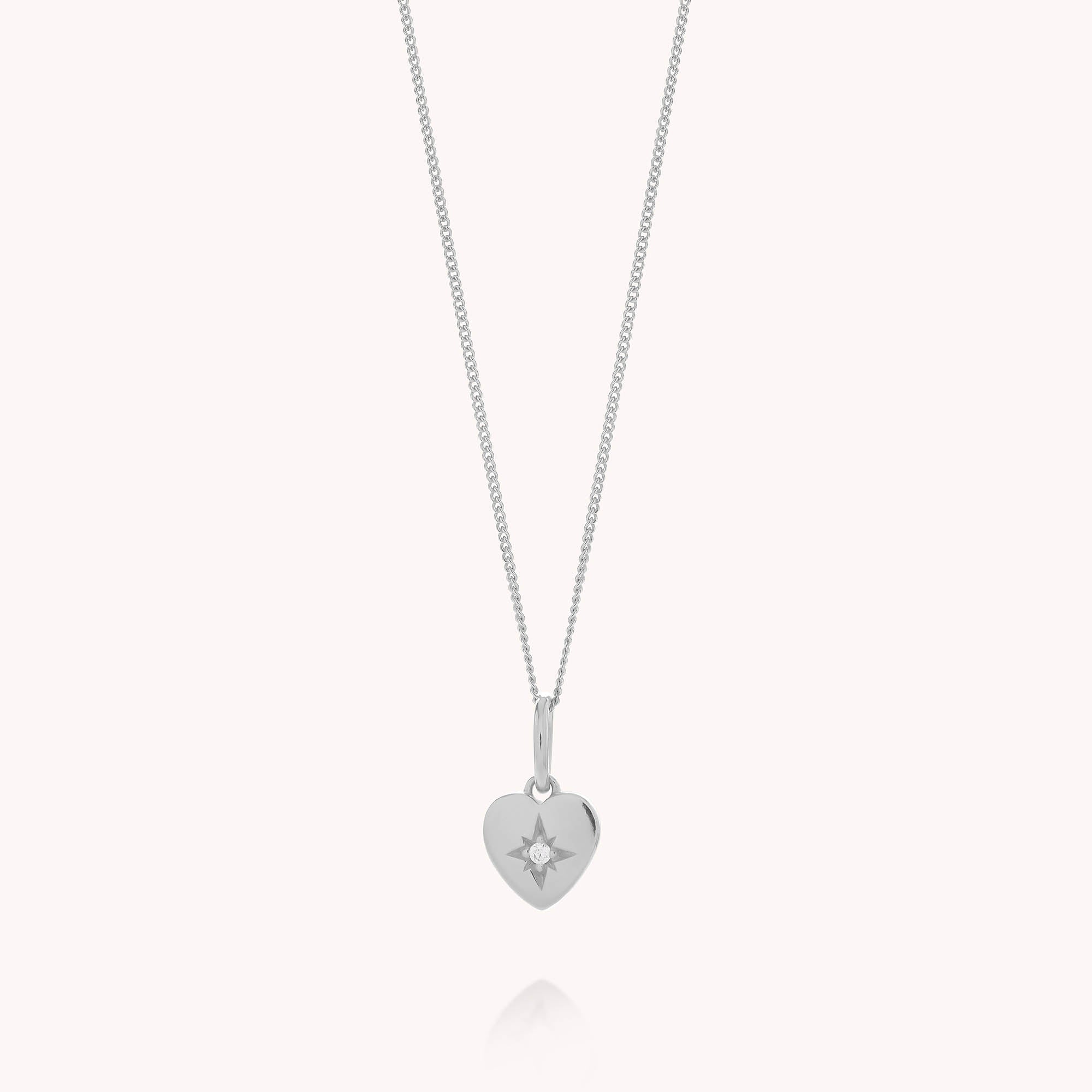 Introducing the Wish Heart Necklace—an elegant eco sterling silver necklace featuring a heart-shaped pendant delicately engraved with a small starburst design at its center.