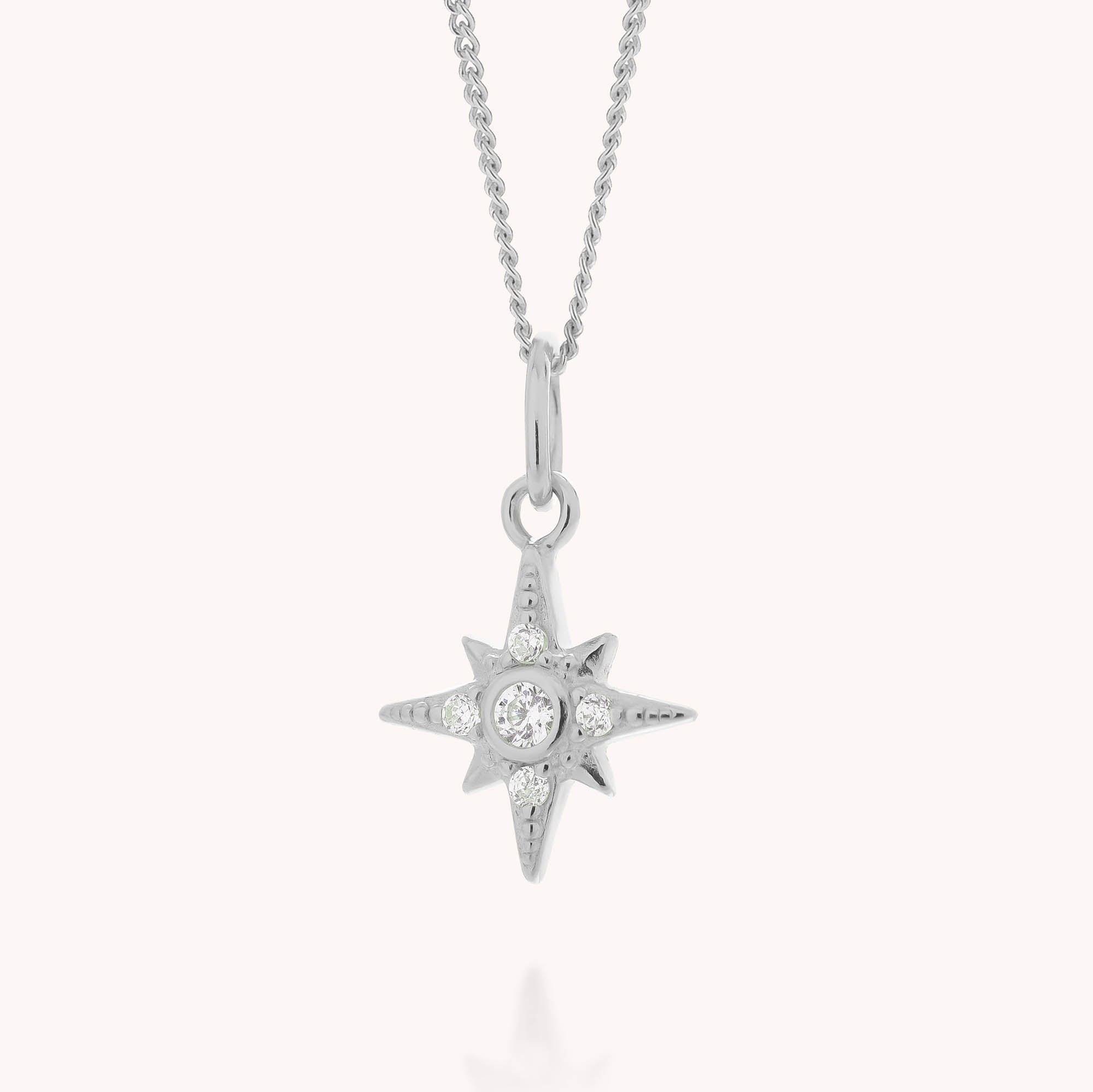 Celestial Star Necklace with a north star pendant, showcasing a central round cubic zirconia and smaller stones on each point, suspended from a delicate chain against a white background.