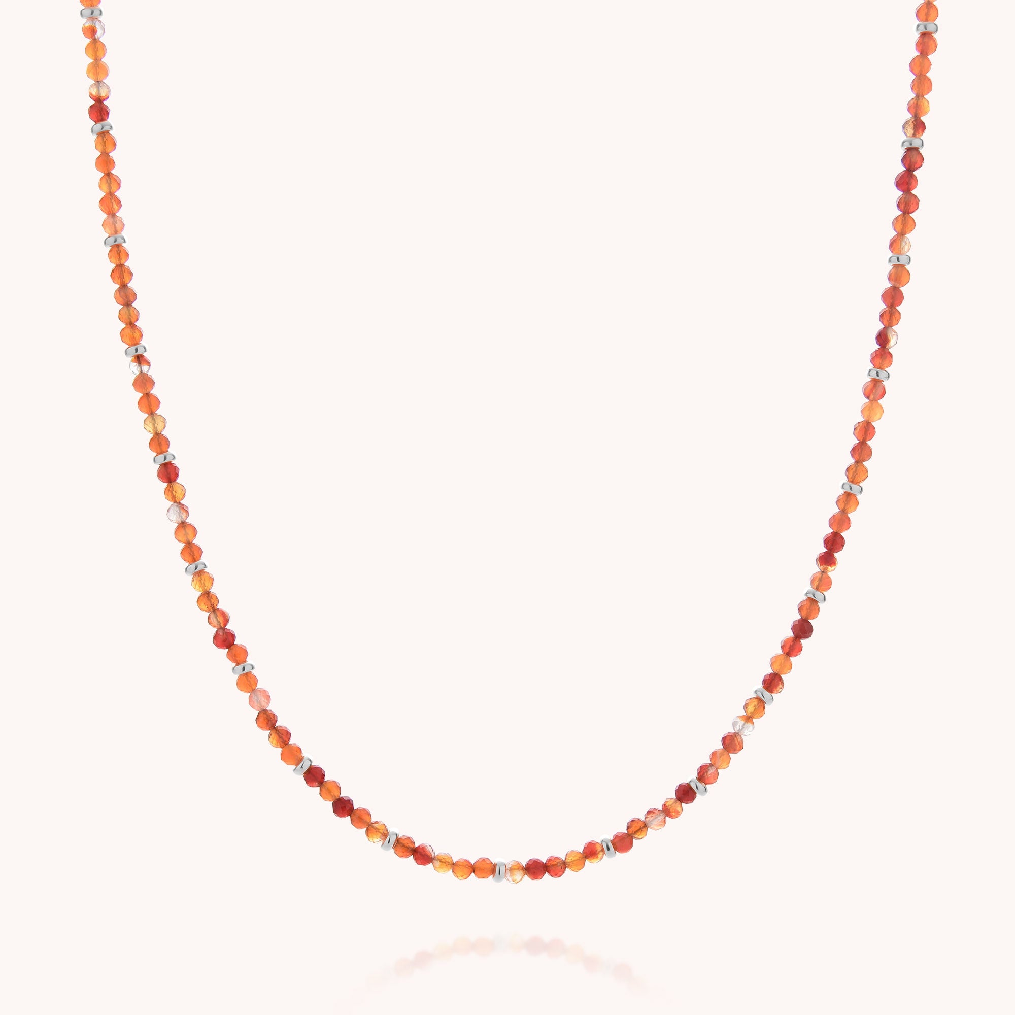 The Carnelian July Birthstone Orbit Necklace features small, round carnelian beads in a beautiful spectrum of orange and red hues, strung closely together and showcased on a plain white background—an elegant gemstone piece that captures vibrant beauty and makes a perfect gift for anyone seeking a July birthstone accessory.