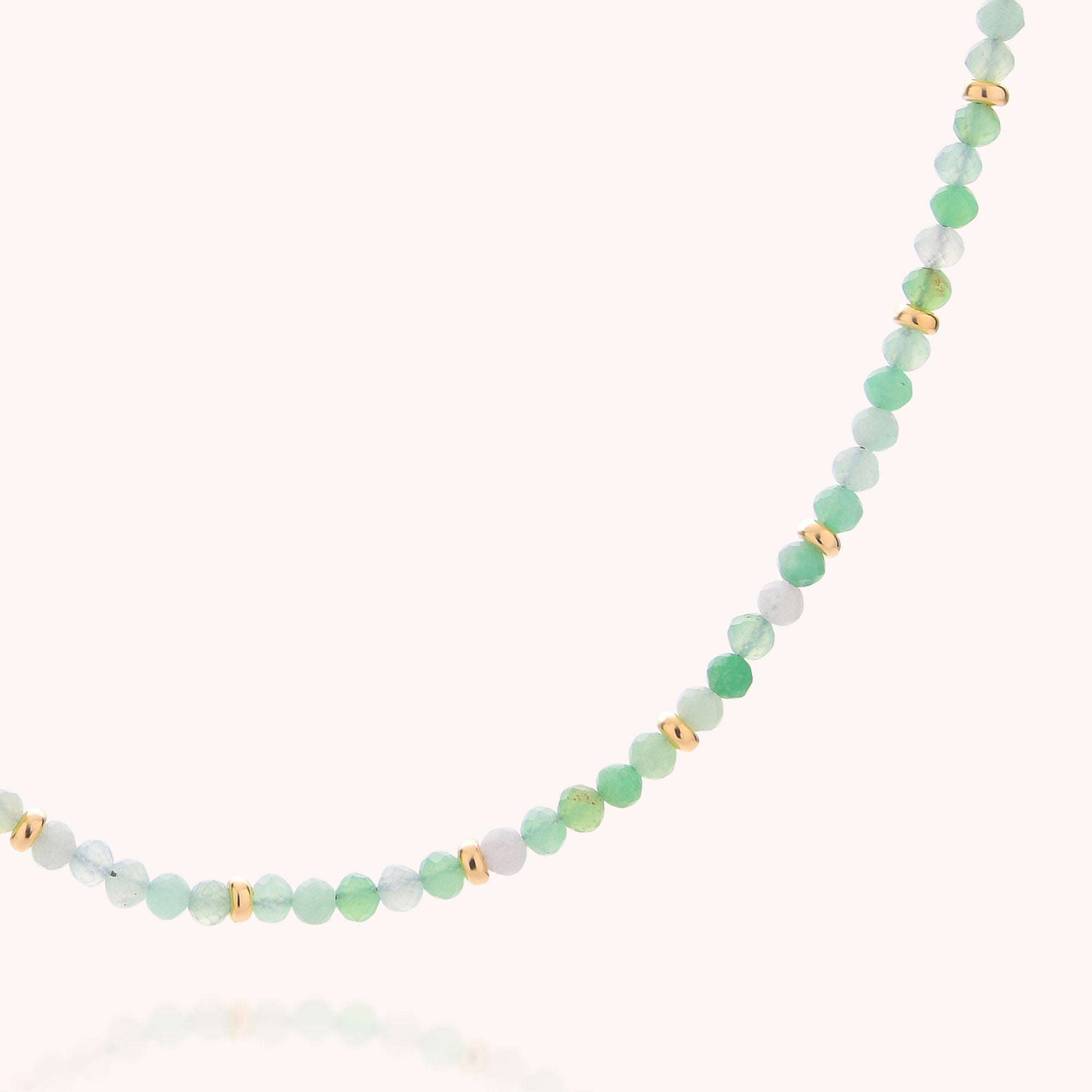The Chrysoprase May Birthstone Orbit Necklace showcases delicate, round pale green chrysoprase beads accented with spaced gold details, all handcrafted along a fine strand and set against a simple, light background.