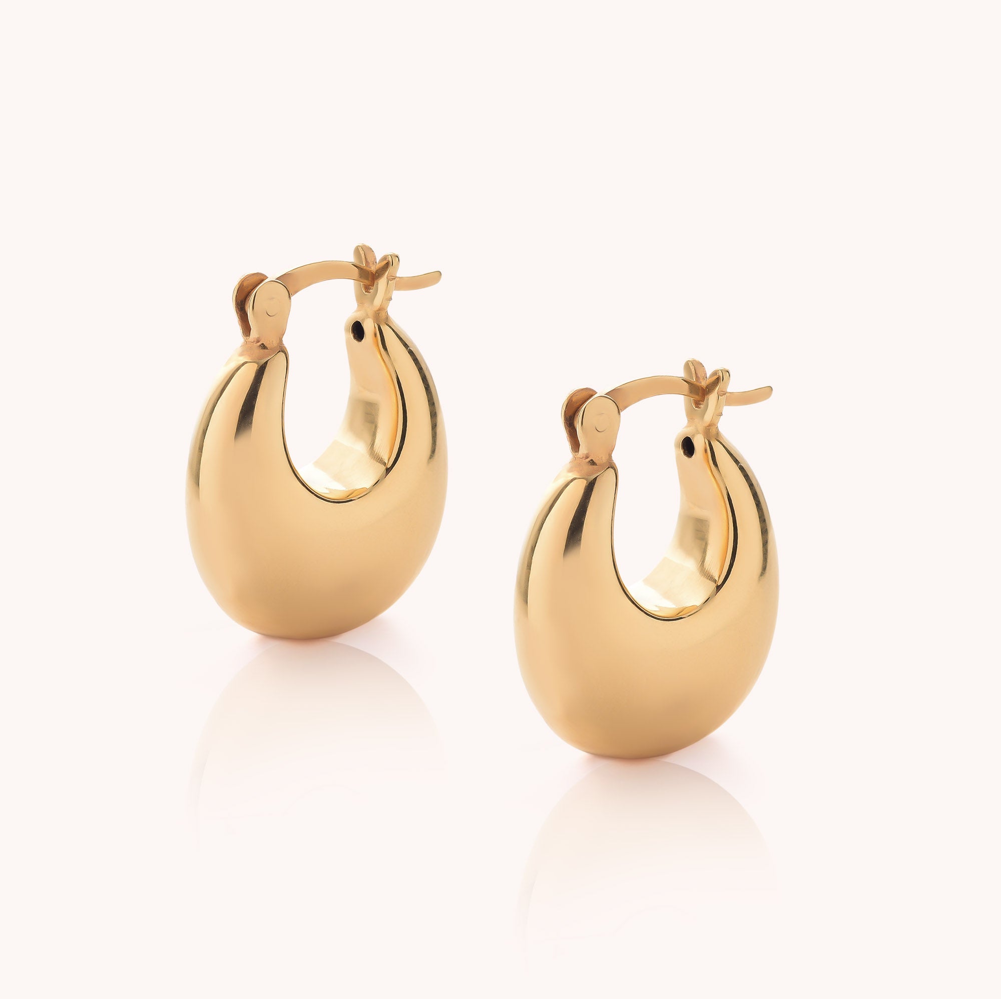 Introducing the Dome Hoop Earrings: a pair of shiny gold earrings with a rounded, chunky dome design, shown against a light background. These sculptural Dome Hoop Earrings add the perfect touch of everyday elegance to any look.