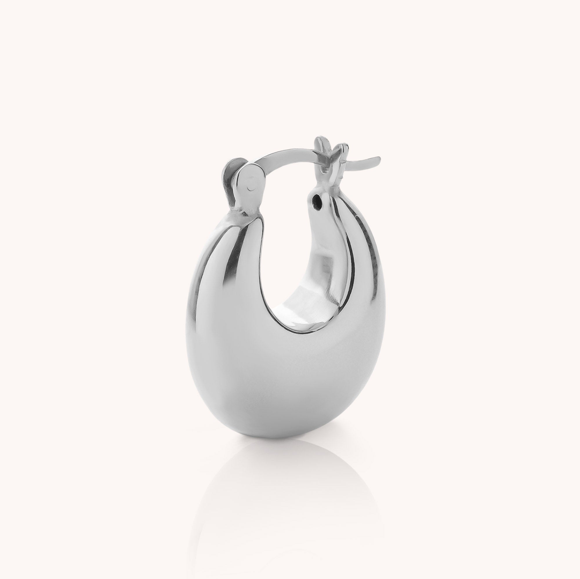 A single Dome Hoop Earring, showcasing its polished silver dome shape and latch-back clasp, is displayed upright against a plain white background—highlighting the timeless design of these sculptural earrings ideal for everyday wear.