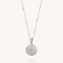 The Starlight Keepsake Locket Necklace features a sterling silver round pendant with a central gemstone and a beaded chain, capturing the timeless charm of celestial-inspired jewelry.