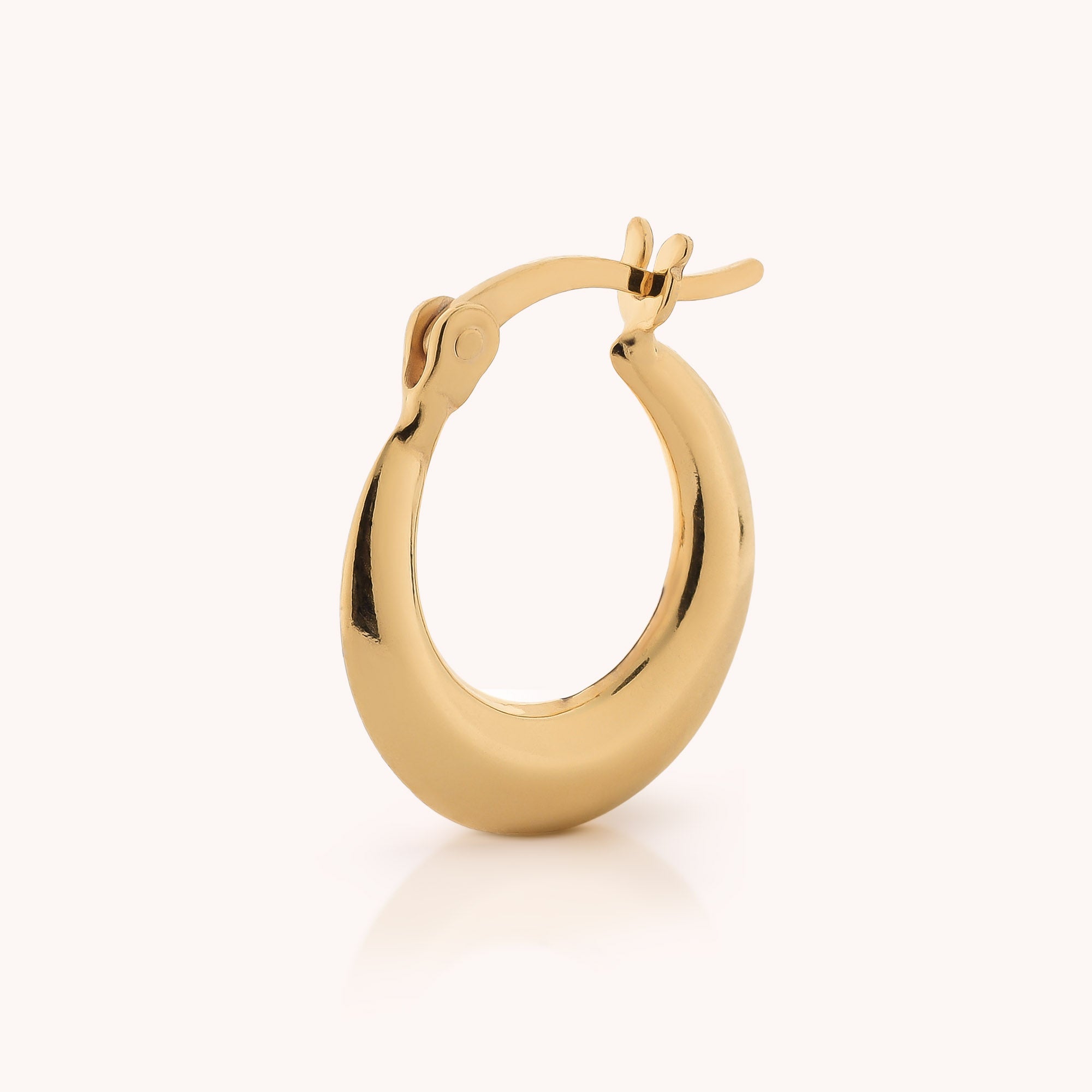 A single Contour Hoop Earring with a smooth, polished surface and a hinged clasp, reminiscent of sculptural hoop designs, displayed upright on a plain light background.
