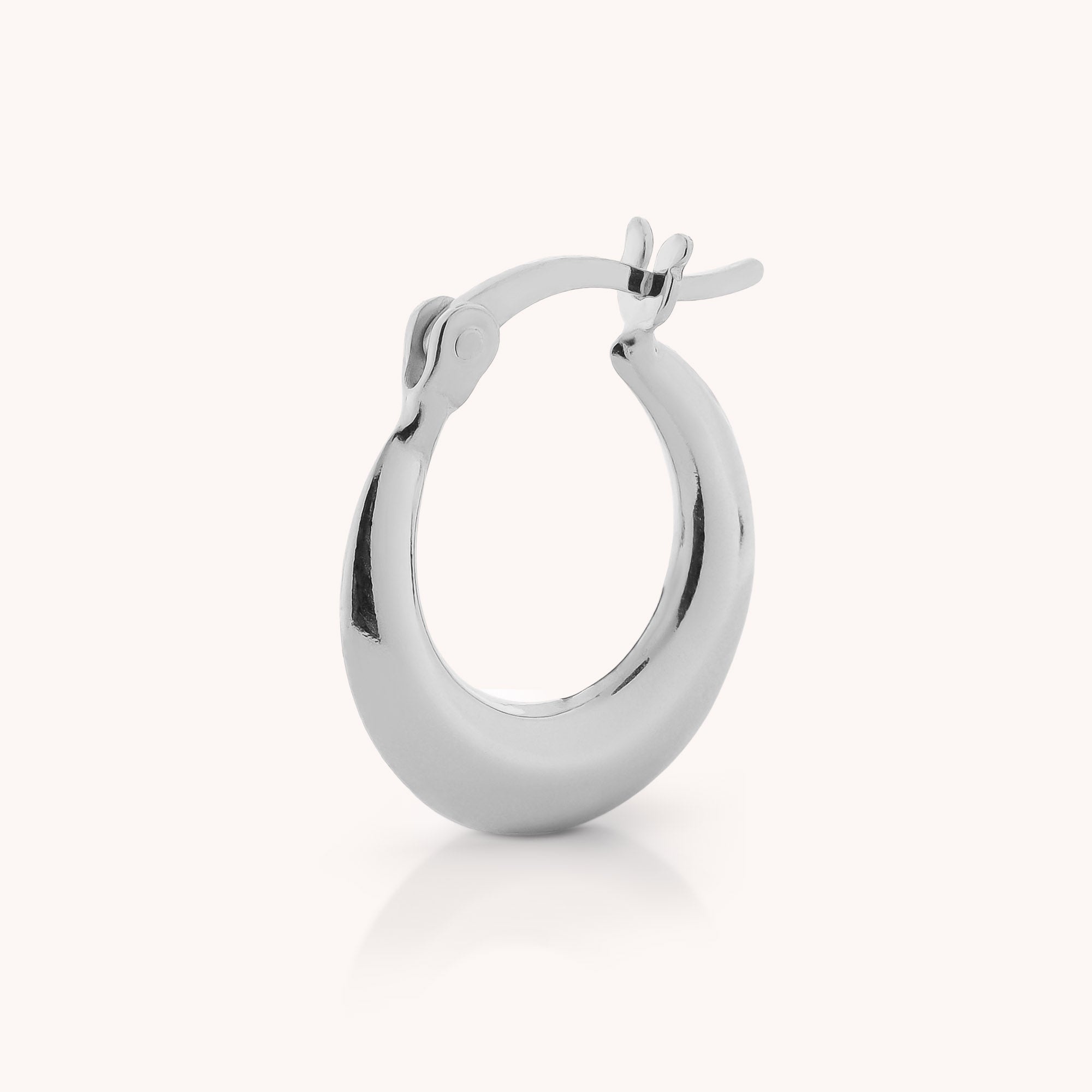 Standing upright on a light, neutral background is the Contour Hoop Earring—a single, polished sterling silver sculptural hoop featuring a latch-back closure.
