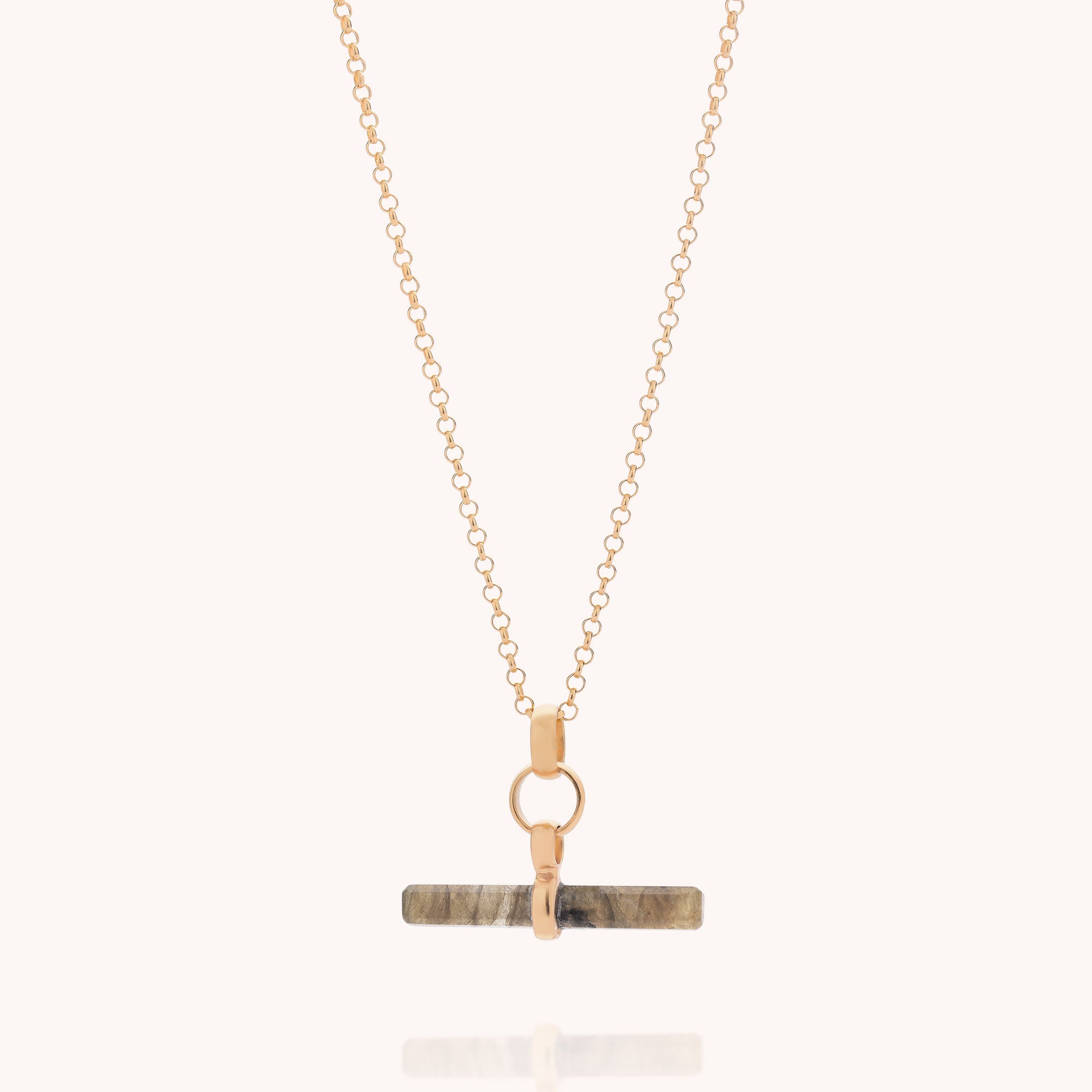 Introducing the Labradorite T-Bar Necklace—a gold chain necklace featuring a horizontal rectangular labradorite stone pendant attached by a gold clasp, elegantly displayed on a light background. A stunning addition to any gemstone jewellery collection.