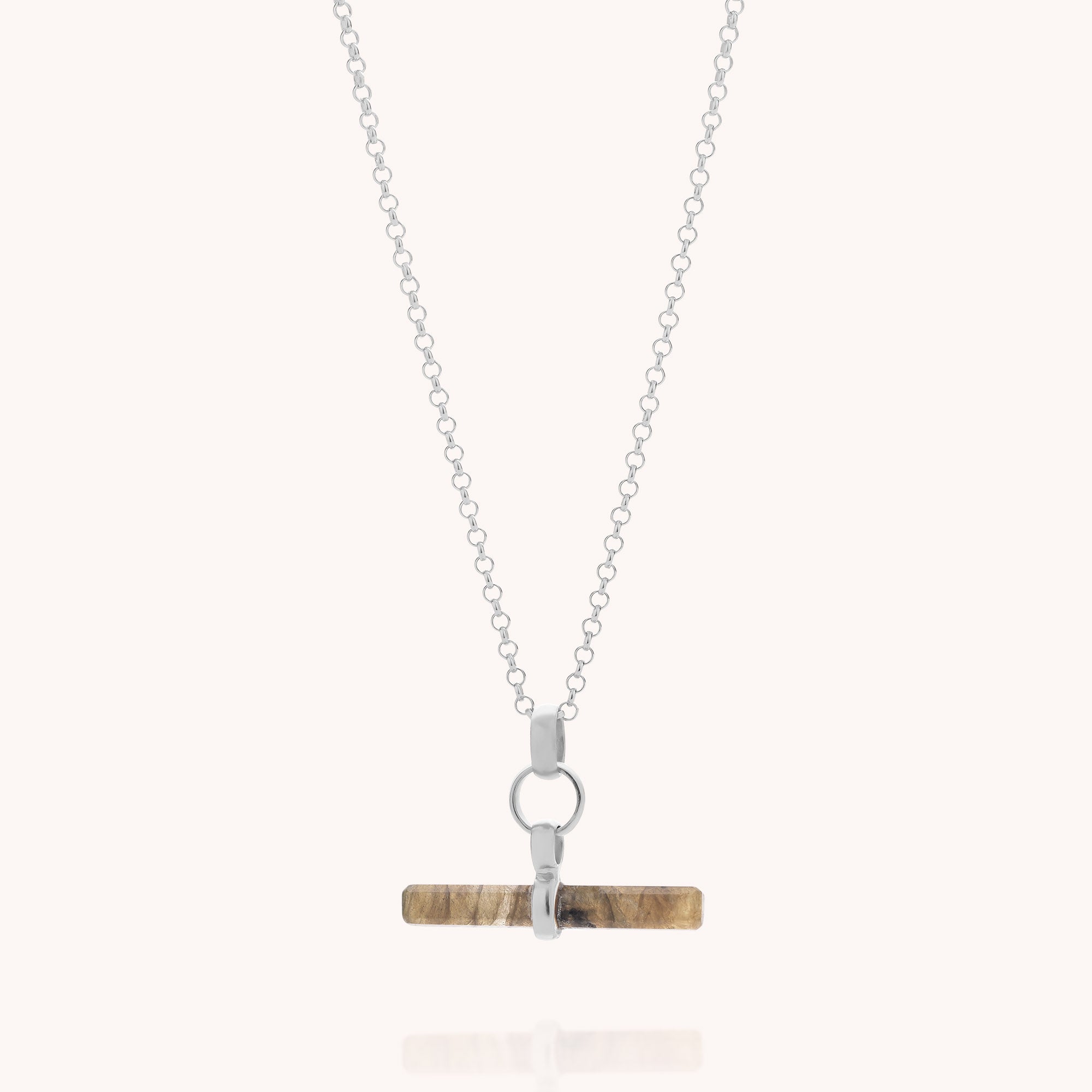 The Labradorite T-Bar Necklace showcases a silver chain with a horizontal, cylindrical labradorite stone pendant featuring brown and tan marbling, set in a simple silver T-bar setting—an elegant addition to any gemstone jewellery collection.