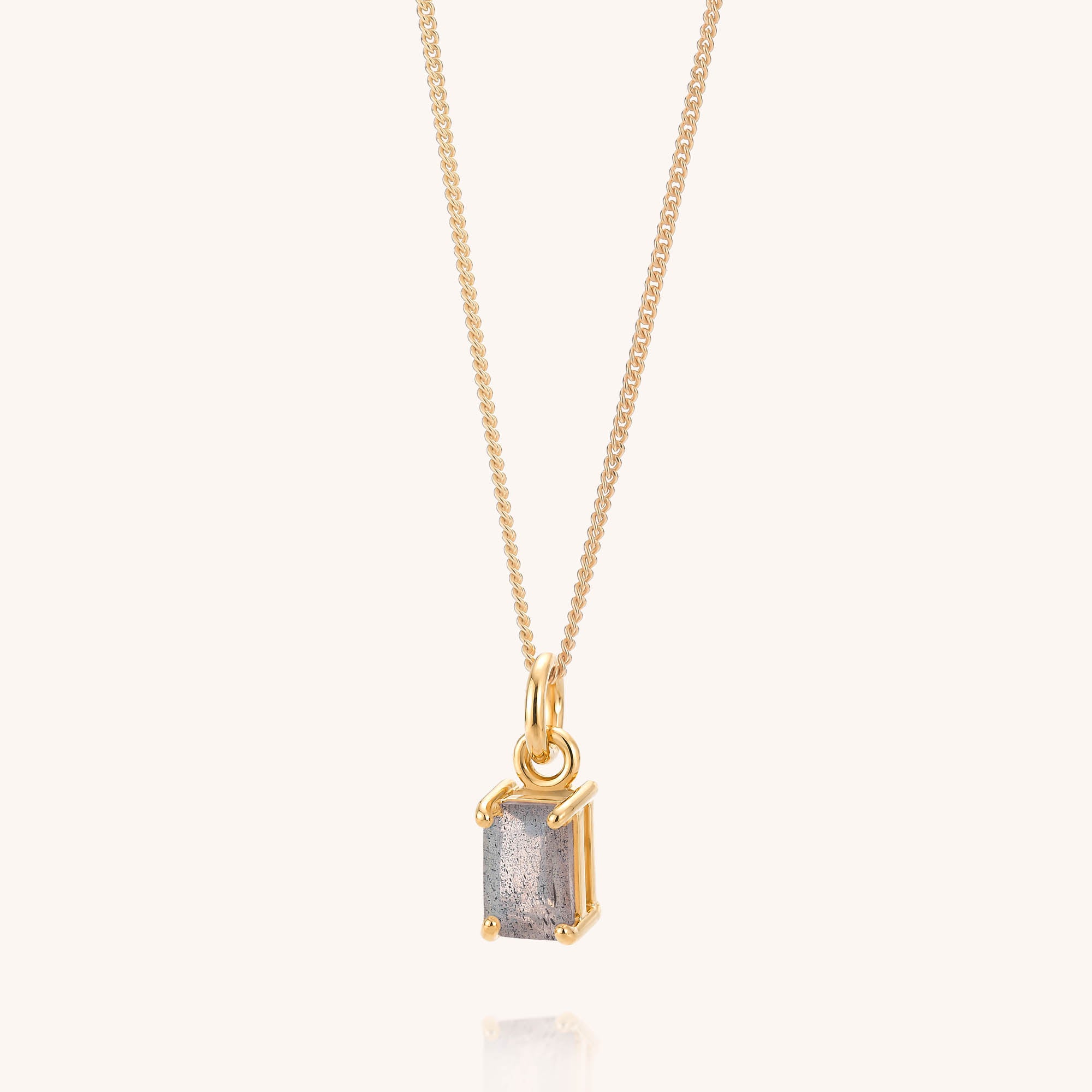 Labradorite Octavia Necklace featuring a rectangular, raw gray Labradorite pendant set in a simple gold frame on a gold chain, displayed against a plain light background.
