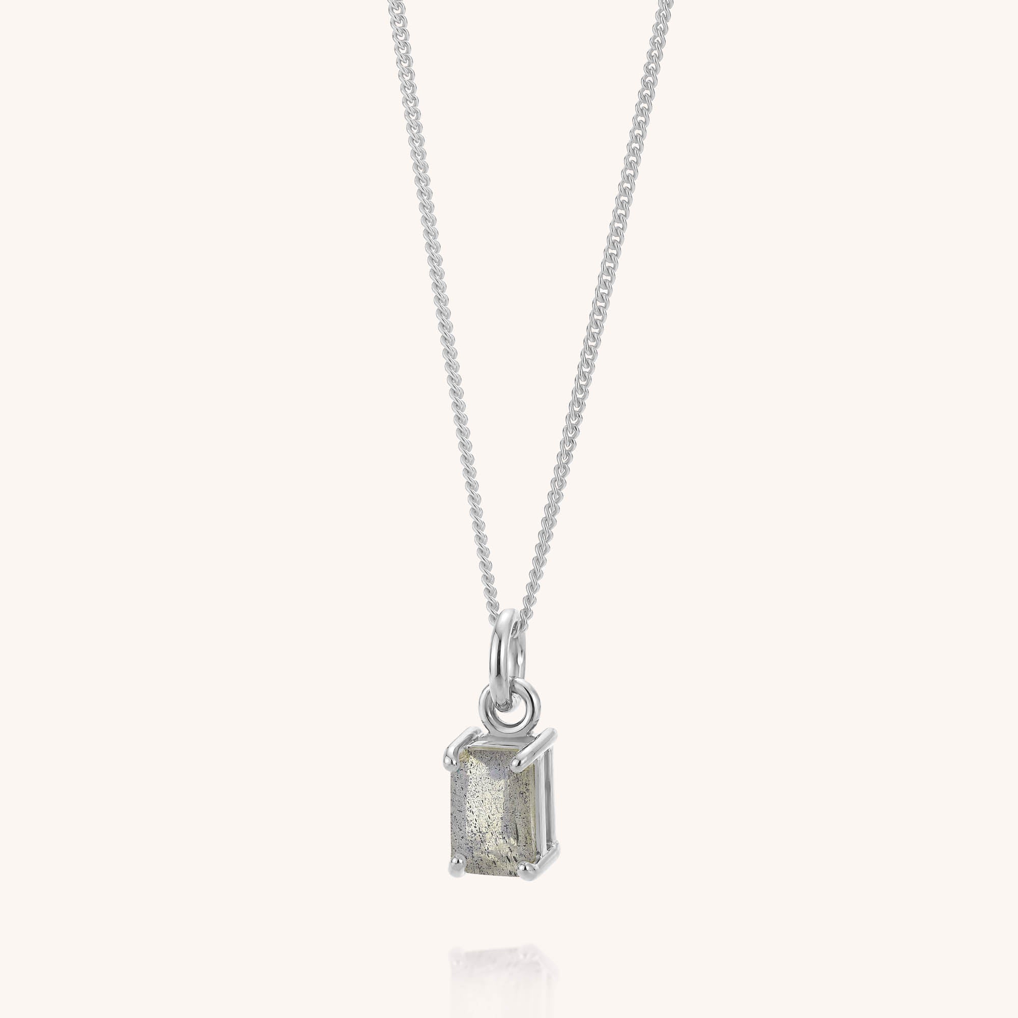 The Labradorite Octavia Necklace features a sterling silver chain and a rectangular, faceted labradorite stone pendant set in a minimalist four-prong setting, elegantly displayed against a plain white background—perfect for everyday wear.