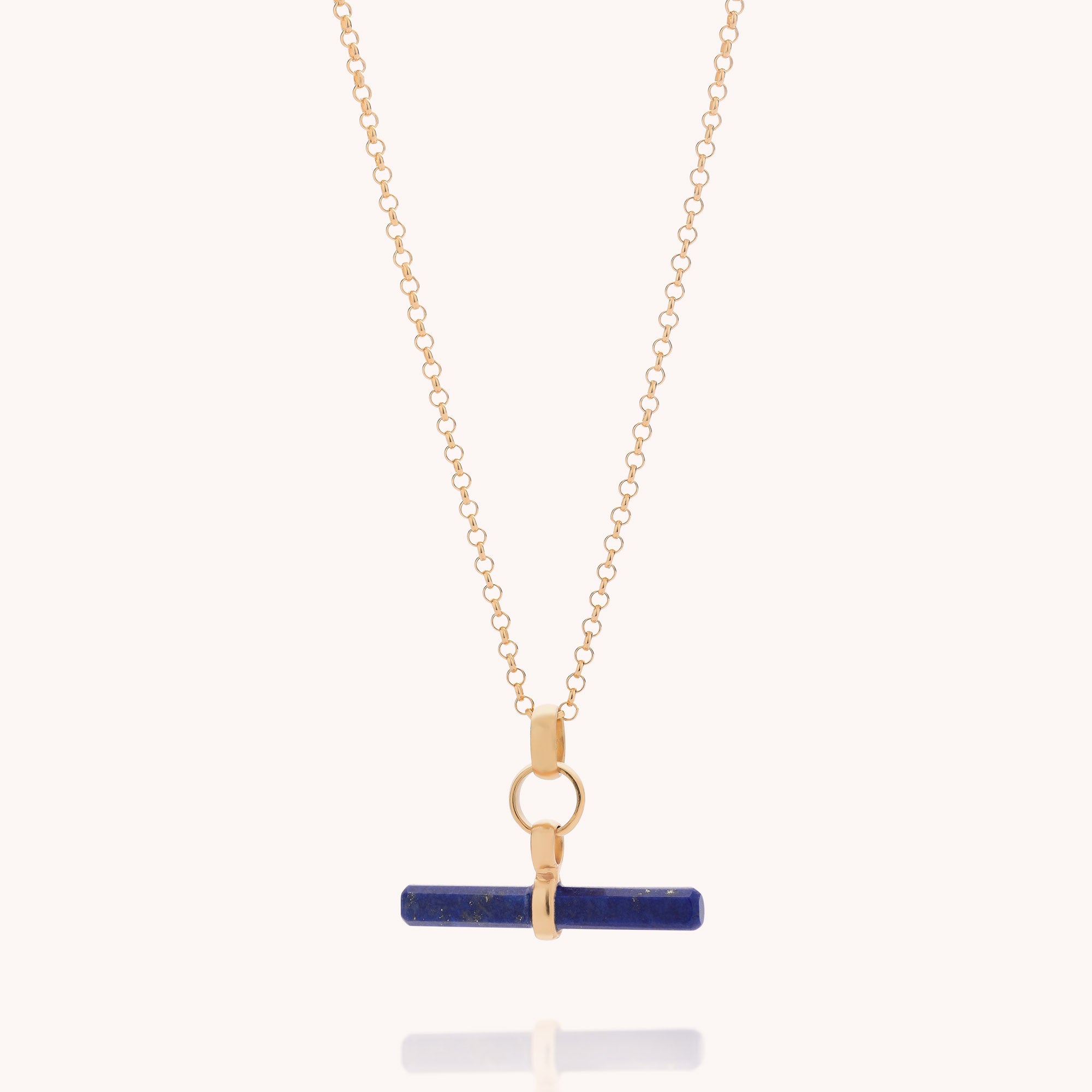 Lapis T-Bar Necklace featuring a gold chain with a horizontal blue bar gemstone pendant reminiscent of lapis lazuli, secured by a small central gold clasp and displayed against a plain light background.