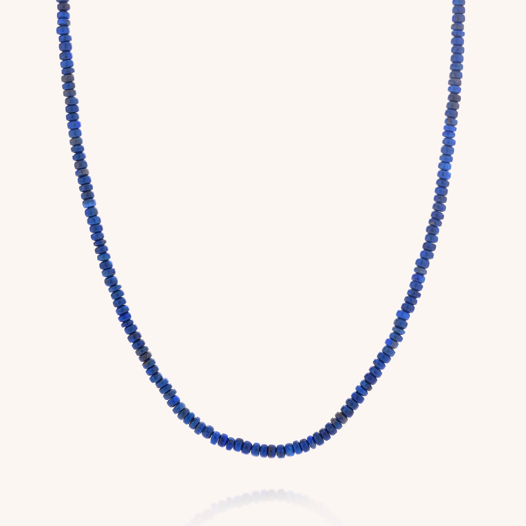 The Lapis Lazuli Rondelle Necklace features small, deep blue beads strung closely together, offering a subtle yet stylish option for men’s birthstone jewelry, shown against a plain white background.