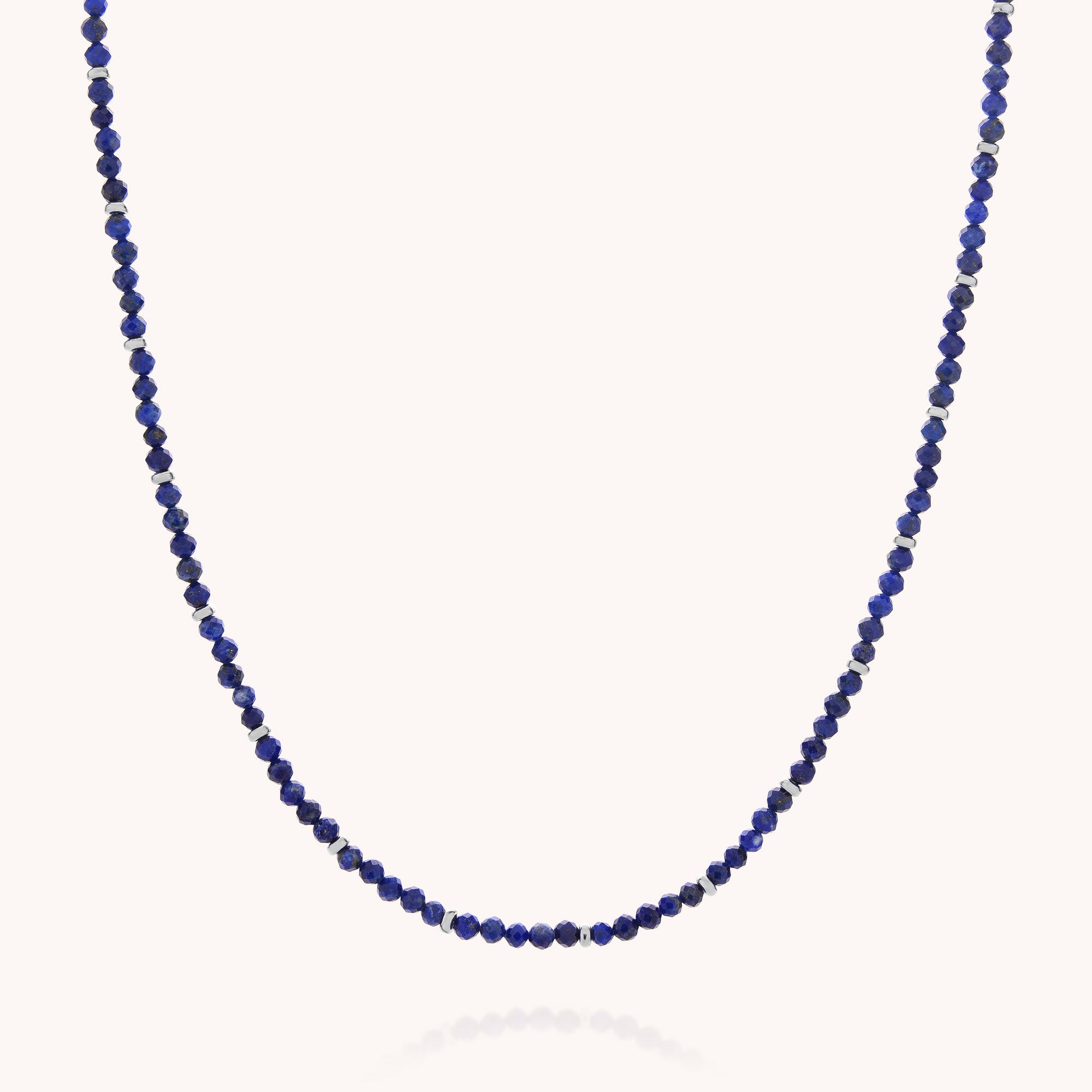 The Lapis September Birthstone Orbit Necklace features small, round deep blue and metallic beads delicately spaced along a thin strand; displayed against a plain light background, this handcrafted piece is an elegant choice for celebrating September birthdays.