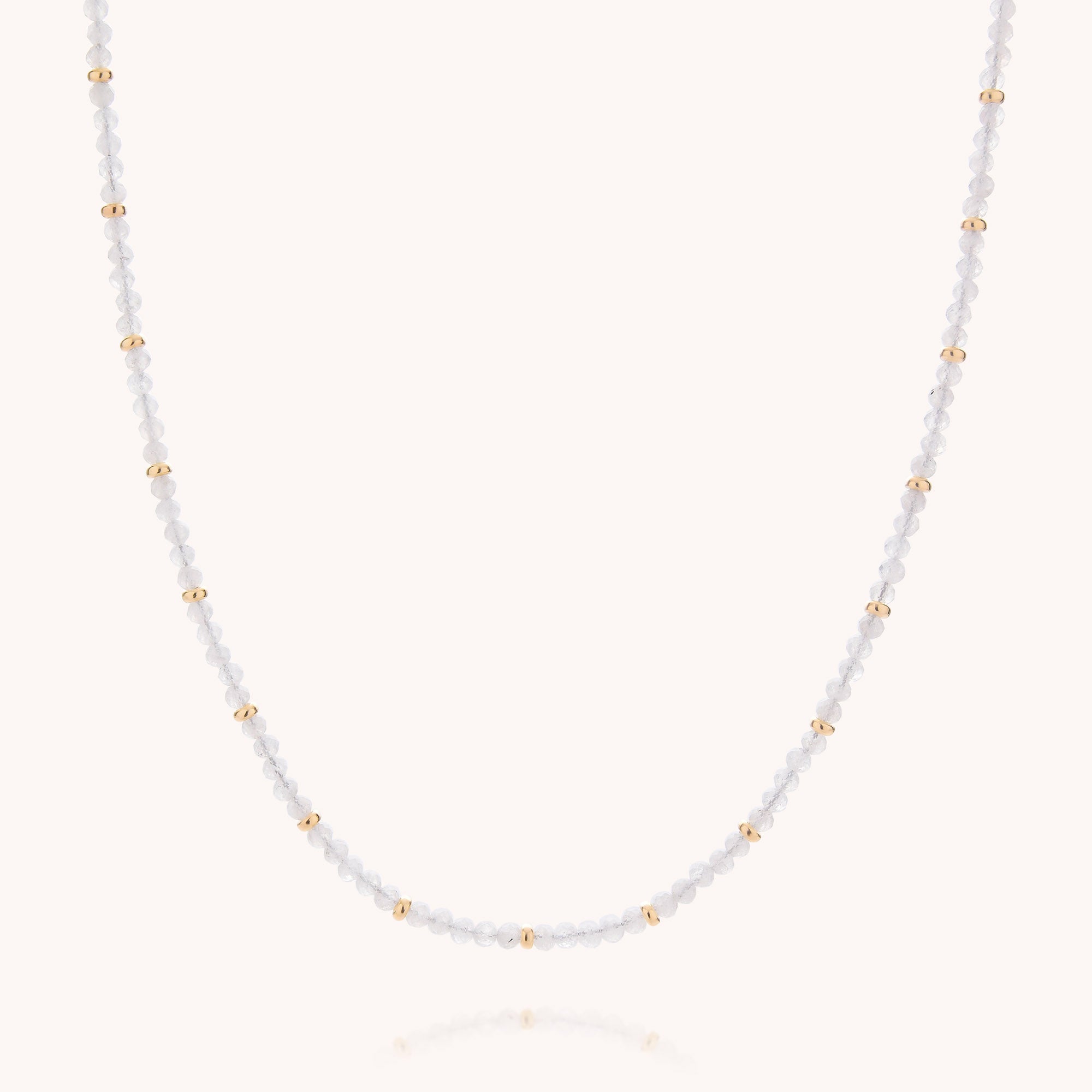 Introducing the Rainbow Moonstone June Birthstone Orbit Necklace—a delicate handcrafted piece featuring small white beads and evenly spaced gold accents on a fine chain. Presented against a light background, this necklace is perfect as a subtle rainbow moonstone accessory or a meaningful June birthstone gift.