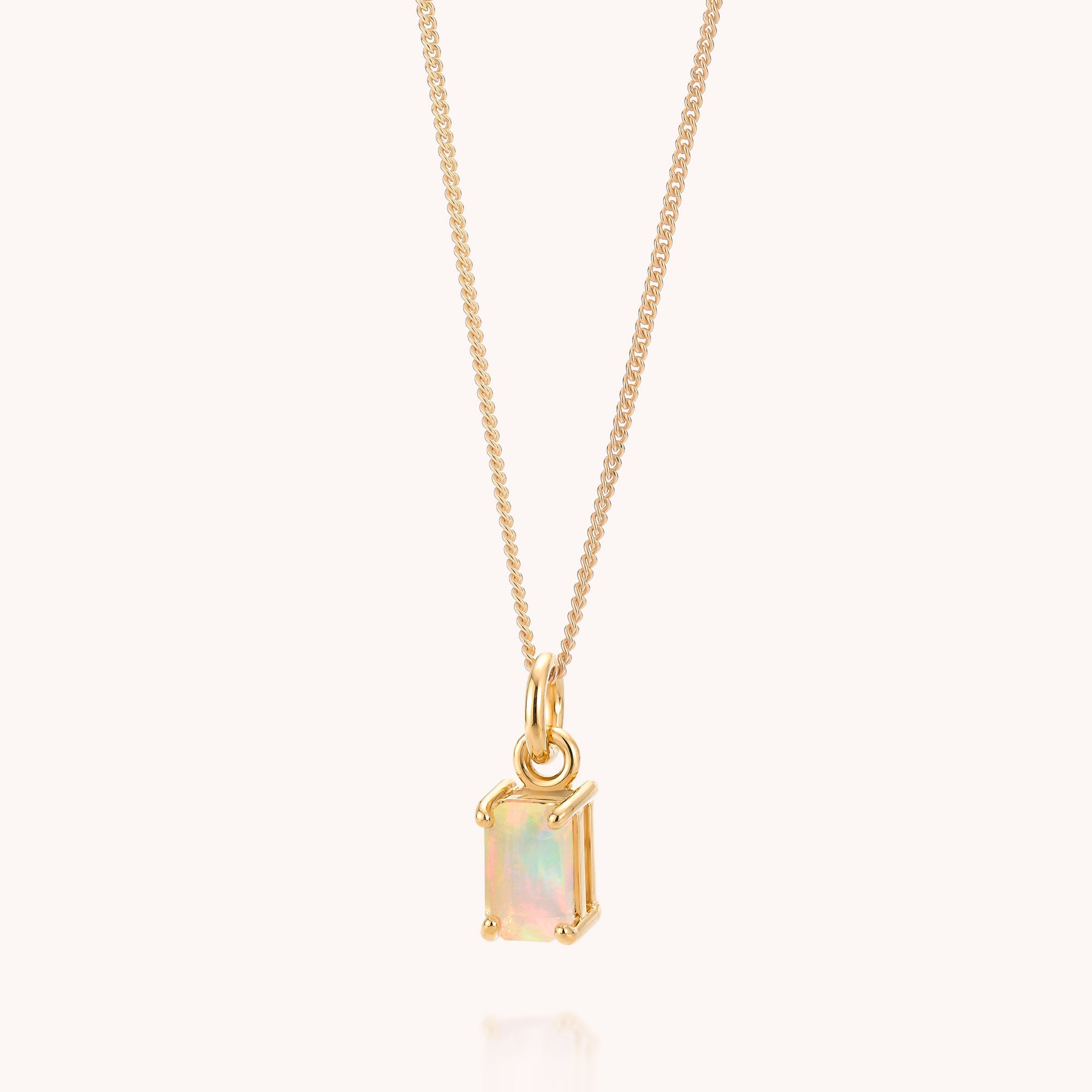 The Opal Octavia Necklace features a rectangular, iridescent Ethiopian opal pendant—October’s captivating birthstone—set in a minimalist gold frame on a gold plated sterling silver chain, elegantly displayed against a light background.
