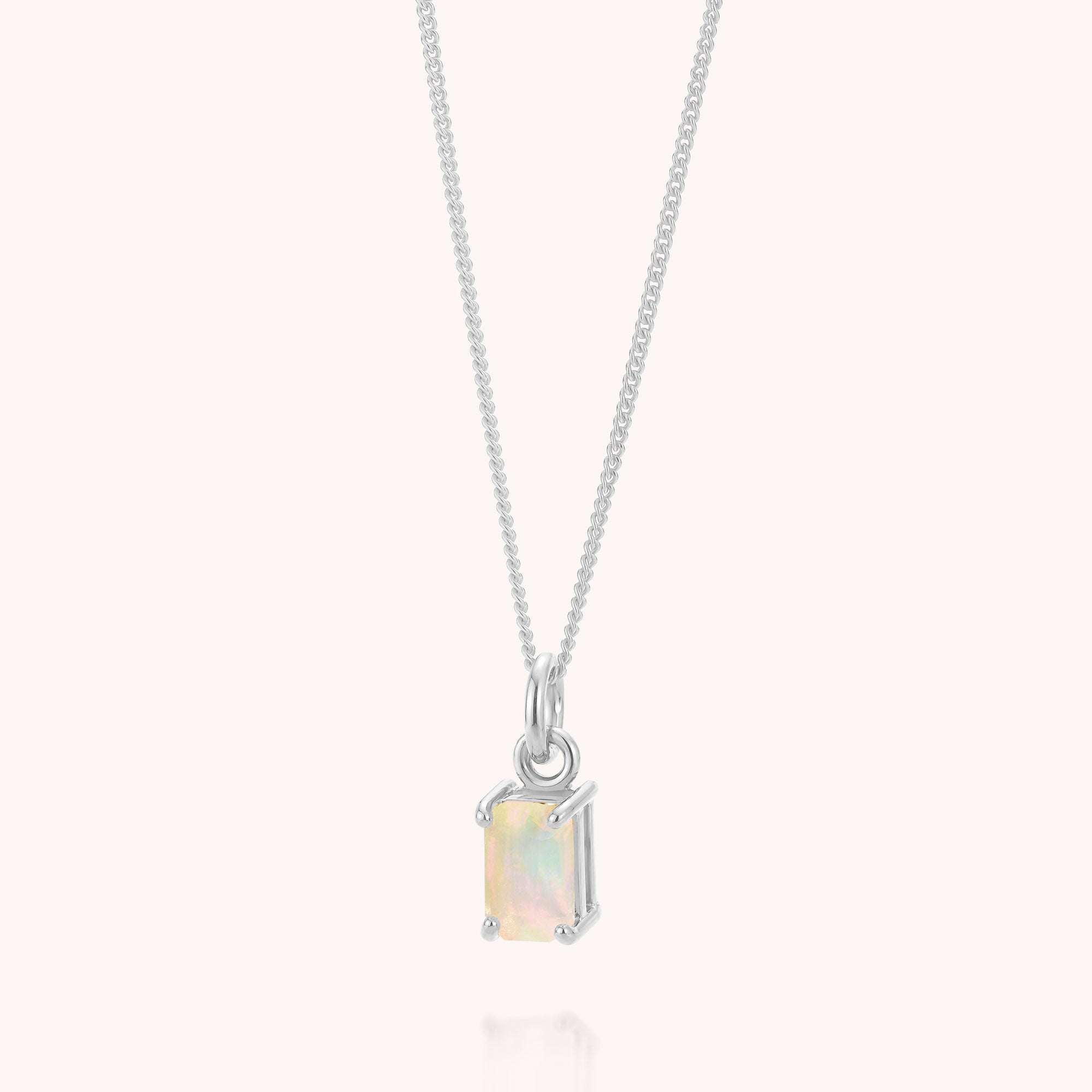 Opal Octavia Necklace: A silver chain necklace showcasing a rectangular, pale Ethiopian opal pendant—the exquisite October birthstone—set in a classic four-prong setting and presented against a simple light background.