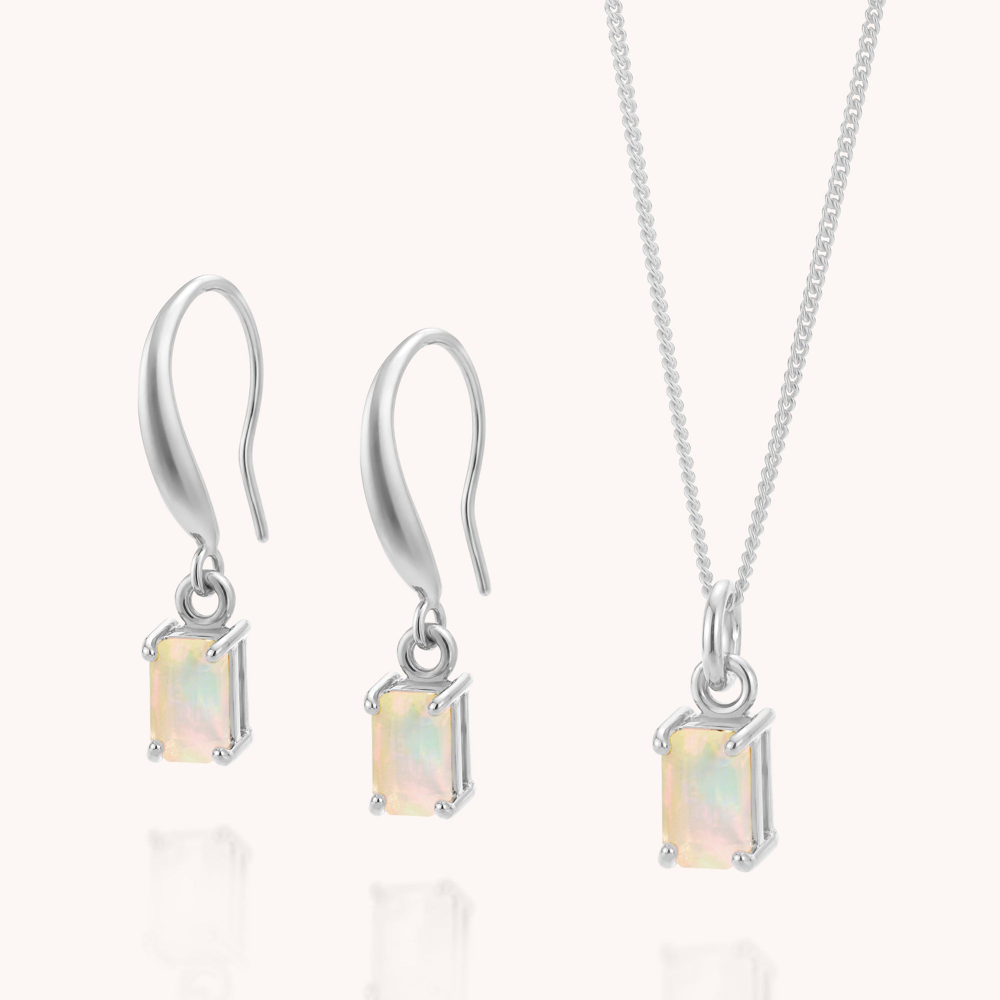 Introducing the Opal Octavia Necklace & Earrings Set—a refined jewelry ensemble featuring a pair of silver drop earrings and a coordinating pendant necklace, each adorned with a rectangular Ethiopian opal gemstone in a secure four-prong setting. Showcasing the vibrant play-of-color for which October’s birthstone is renowned, this elegant set makes an enchanting choice for any occasion.