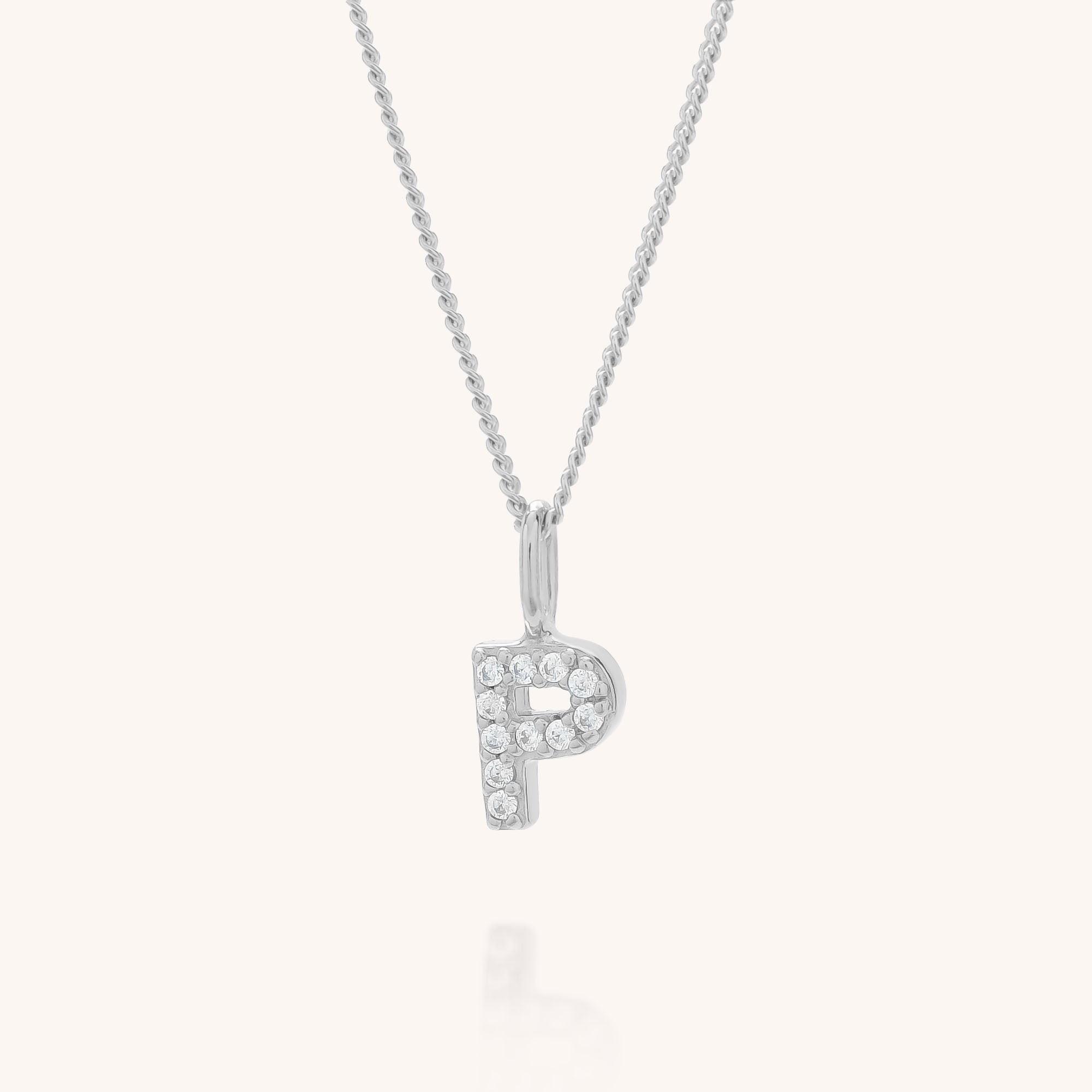 The Initial Sparkle Necklace features a silver pendant shaped like the letter P, adorned with sparkling cubic zirconia, displayed on a plain light background.