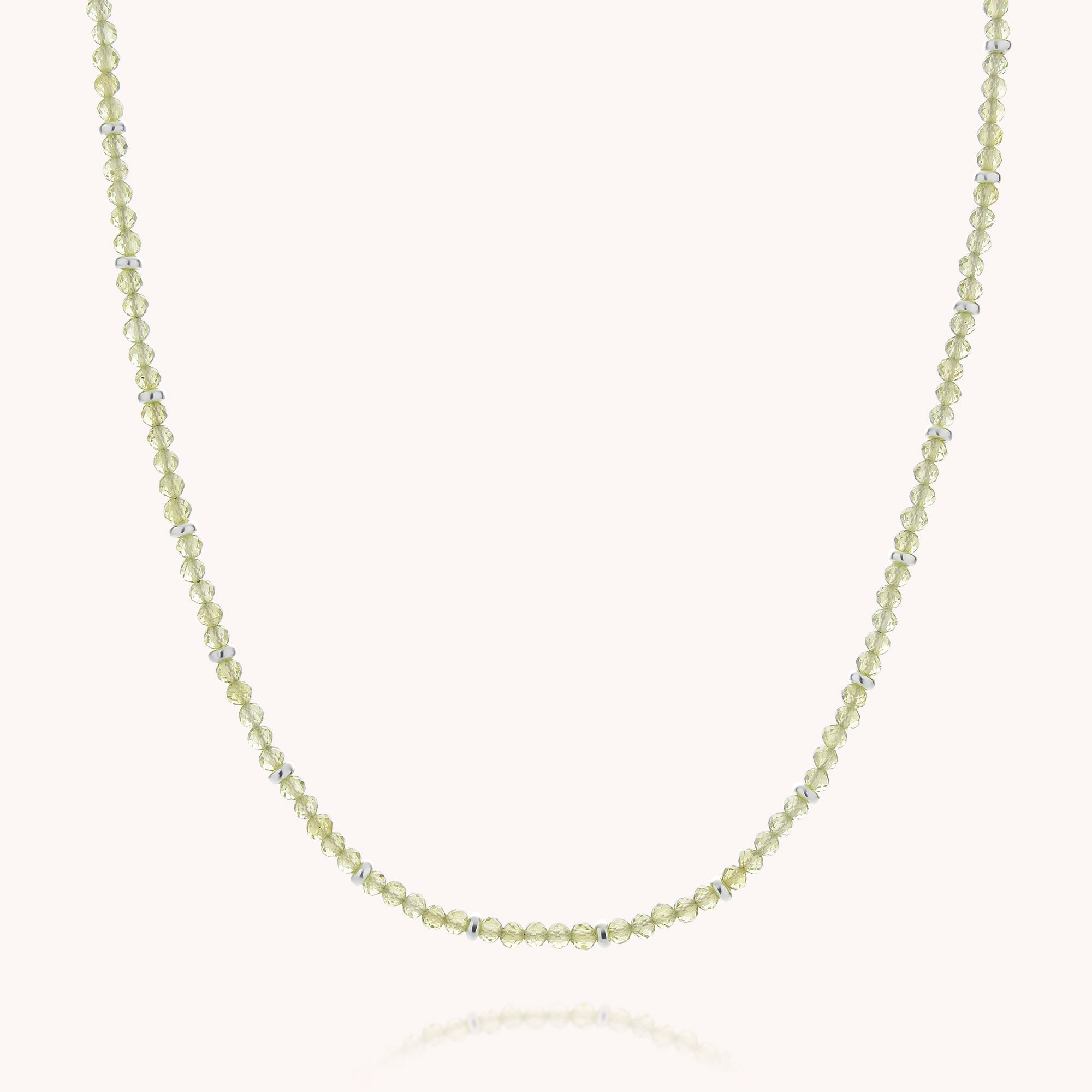 Peridot August Birthstone Orbit Necklace—a delicate piece featuring small, round, pale yellow faceted beads evenly spaced along a thin, transparent string and displayed on a plain white background; an elegant necklace inspired by the August birthstone.