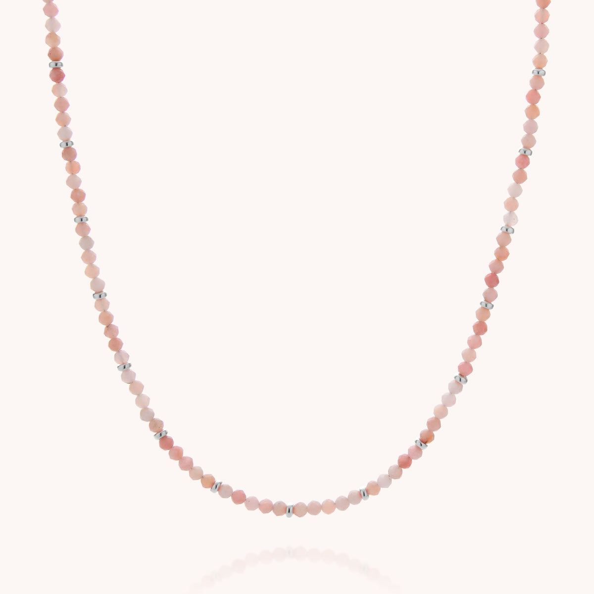 Introducing the Pink Opal October Birthstone Orbit Necklace: a delicate handcrafted piece featuring small, round pink opal beads and spaced silver accents, beautifully displayed against a simple light background—an elegant necklace and a meaningful gift for October birthdays.