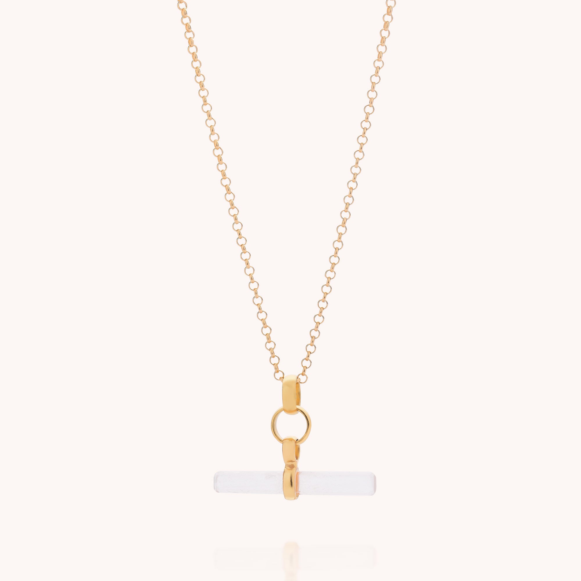 Gold chain necklace featuring a horizontal, cylindrical white quartz pendant secured with gold hardware and displayed against a plain, light background. The Quartz T-Bar Necklace is an elegant example of gemstone jewellery.