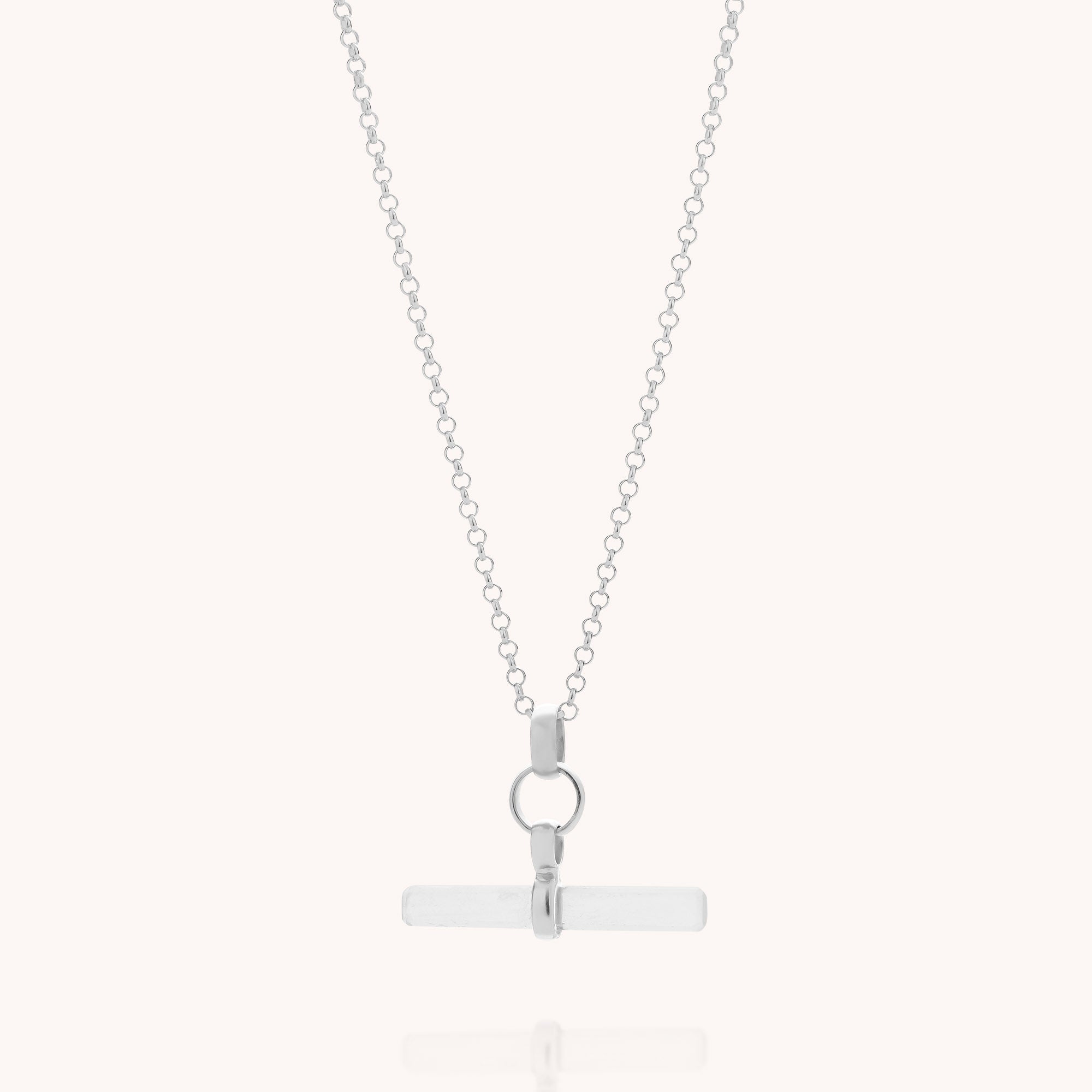 Introducing the Quartz T-Bar Necklace: a delicate sterling silver chain featuring a sleek horizontal bar pendant accented by a circular connector above the bar, all displayed on a plain white background. This minimalist piece captures the timeless elegance of sterling silver jewellery with its contemporary, modern design.