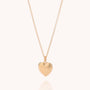 The Scalloped Heart Necklace features a gold-plated, ridged heart-shaped pendant on a delicate chain, displayed against a light background.