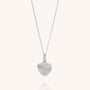 The Celeste Heart Necklace showcases a heart-shaped pendant with an elegant sunburst pattern engraved on its sterling silver surface, suspended from a delicate fine chain. Displayed against a plain, light background, this beautiful necklace exudes timeless charm and sophistication.