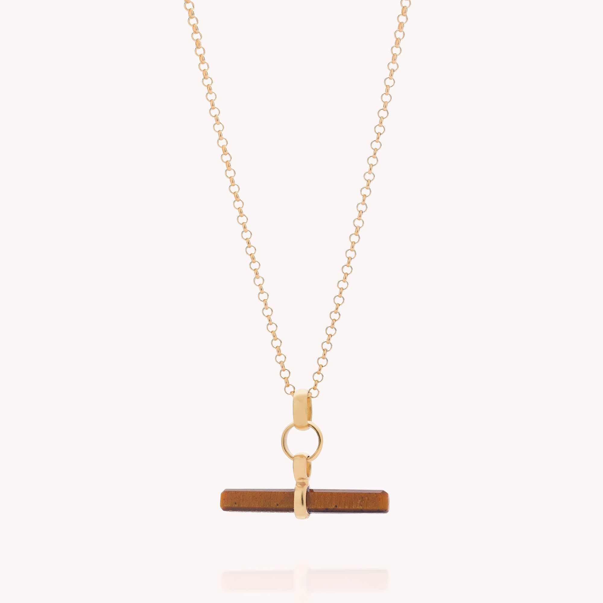 The Gemstone T Bar Necklace features a horizontal brown T-bar pendant suspended from a circular gold connector on a gold chain, displayed against a plain light background.