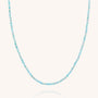 The Amazonite Orbit Necklace features small, round faceted amazonite beads in various shades of light blue, evenly spaced along a thin, nearly invisible gold plated sterling silver string and beautifully displayed against a white background.